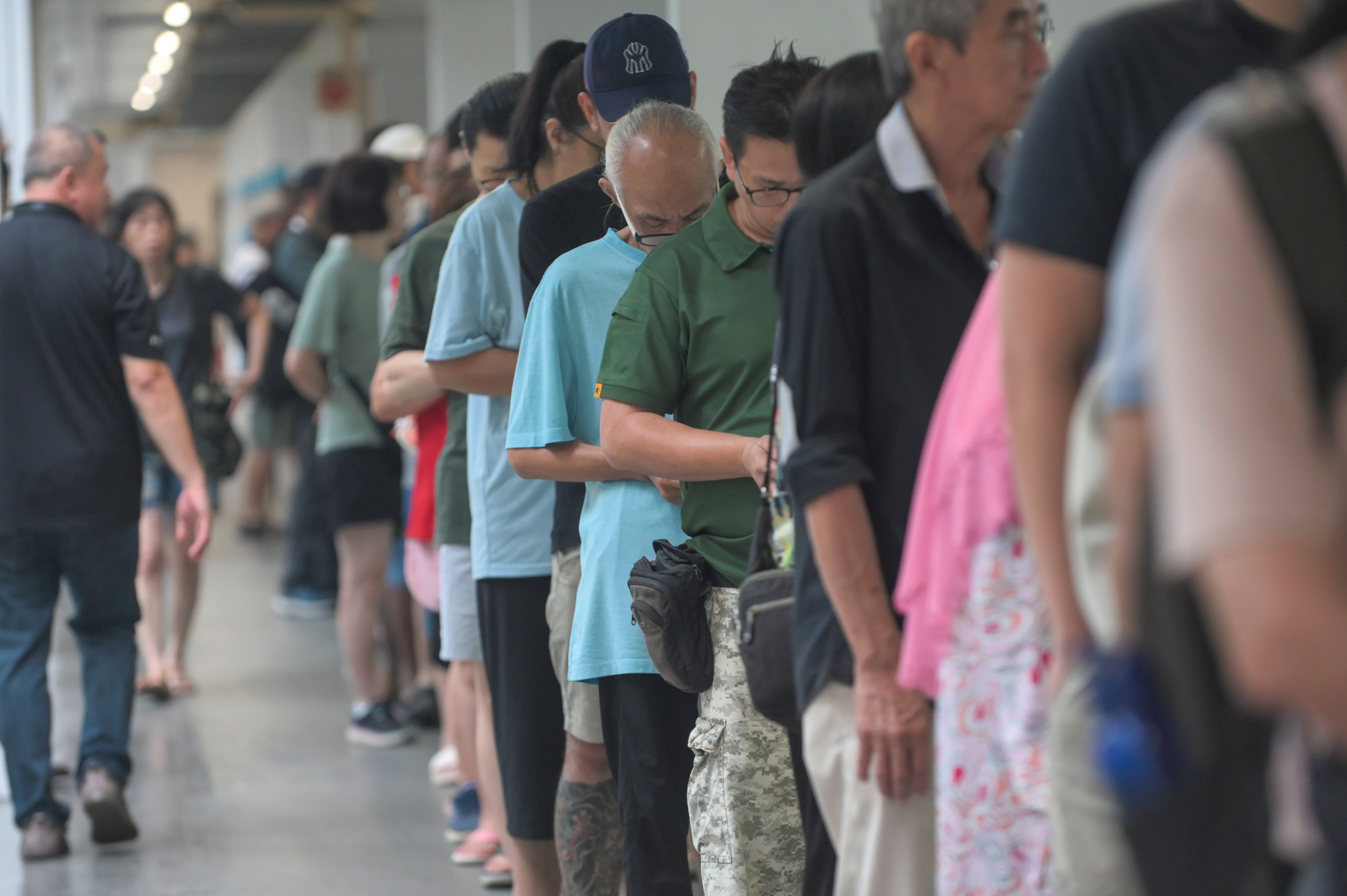 Voters queue to cast their ballots at a polling station in Singapore