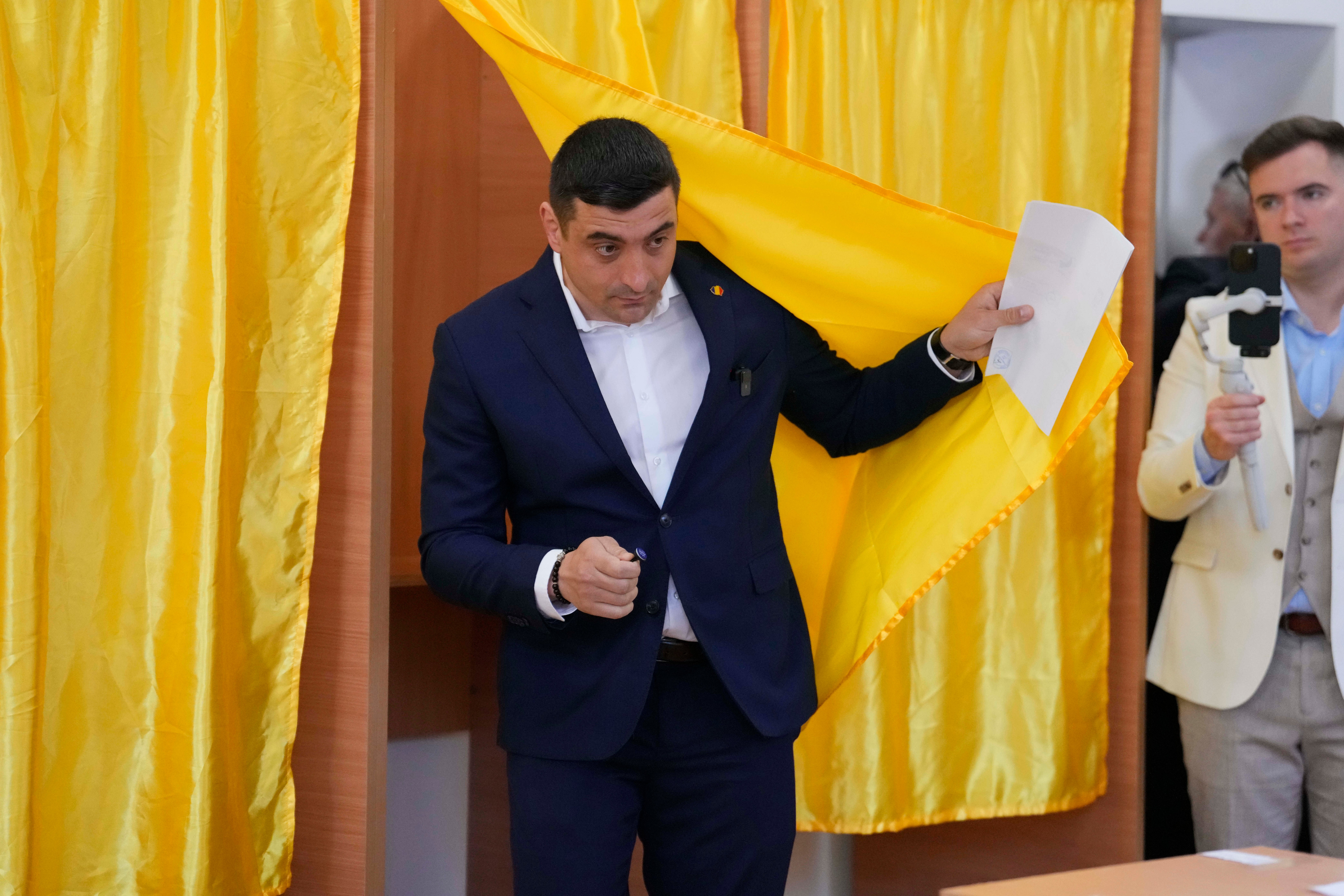 Presidential candidate George Simion exits a voting booth before casting his vote in the first round of the presidential election redo in Bucharest, Romania, Sunday, May 4, 2025. (AP Photo/Vadim Ghirda)