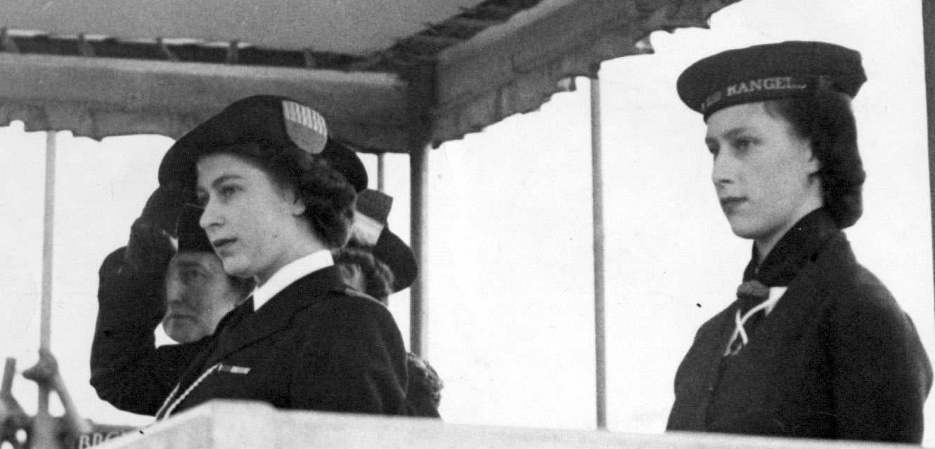Princess Elizabeth, in her uniform of Sea Ranger, and Princess Margaret (right), at Girl Guides march past the year in 1946 a year on from VE Day (PA)