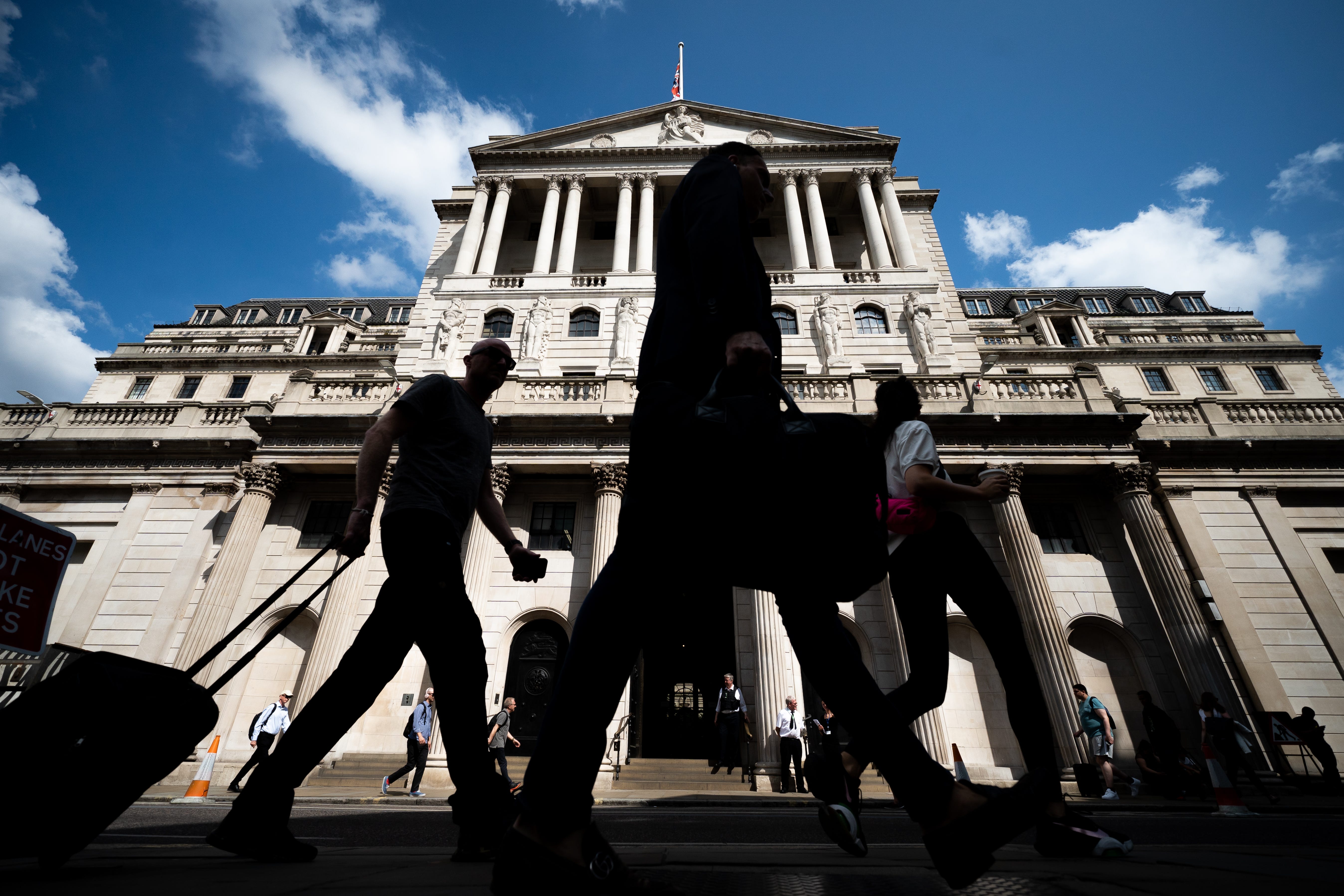 People walk past the Bank of England