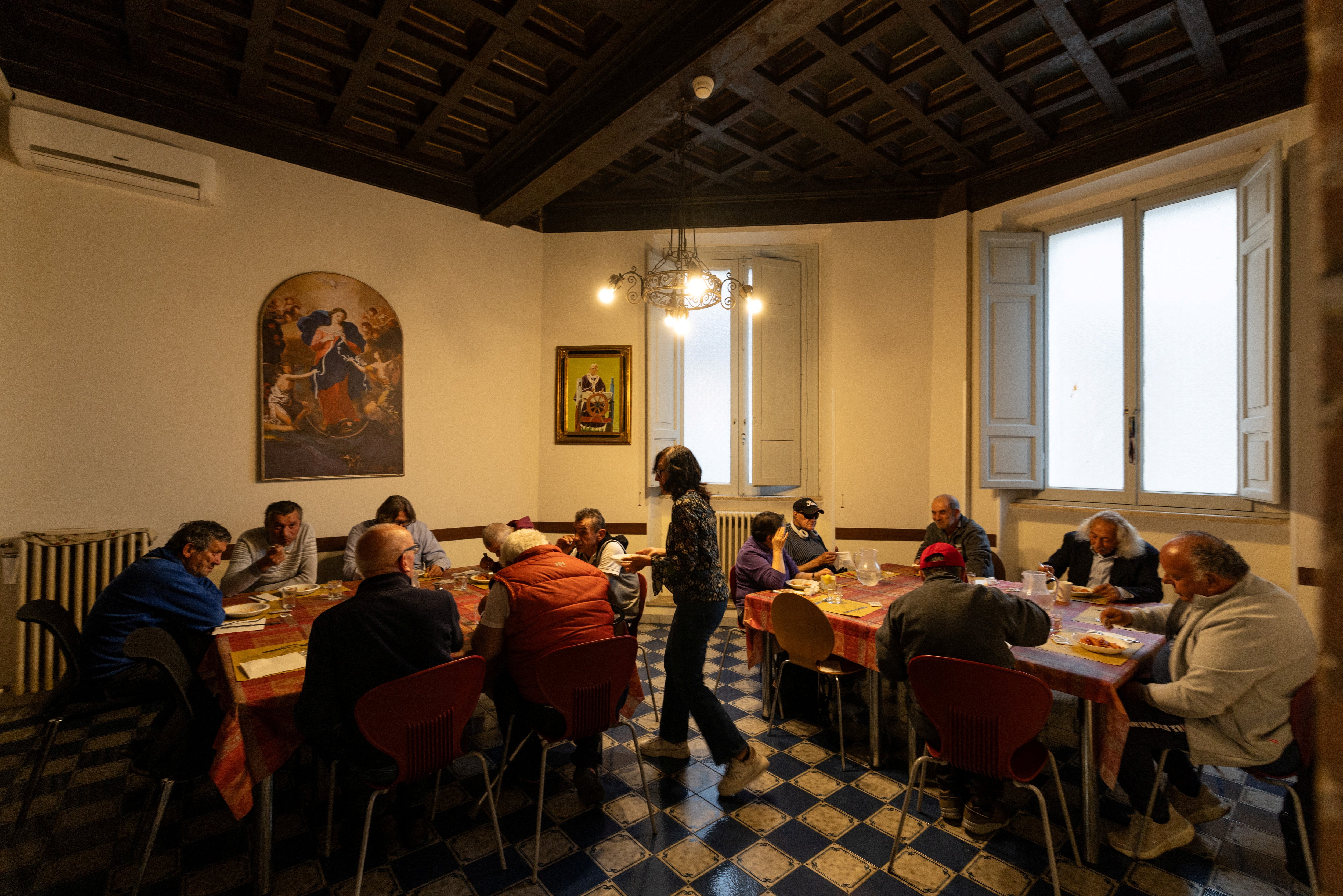 People are served dinner at a shelter run by Sant'Egidio, a Catholic association dedicated to social outreach, in Rome, Italy, April 24, 2025