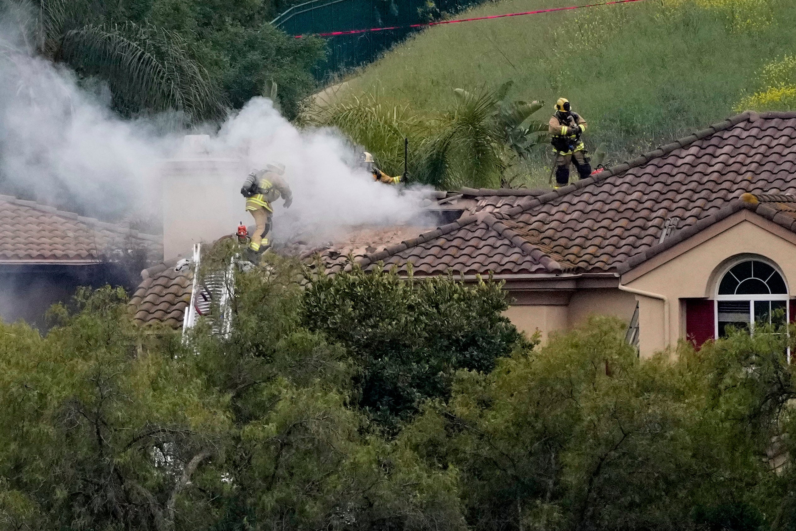 Firefighters work at the site of a plane crash in the Wood Ranch section of Simi Valley, Calif., on Saturday, May 3, 2025
