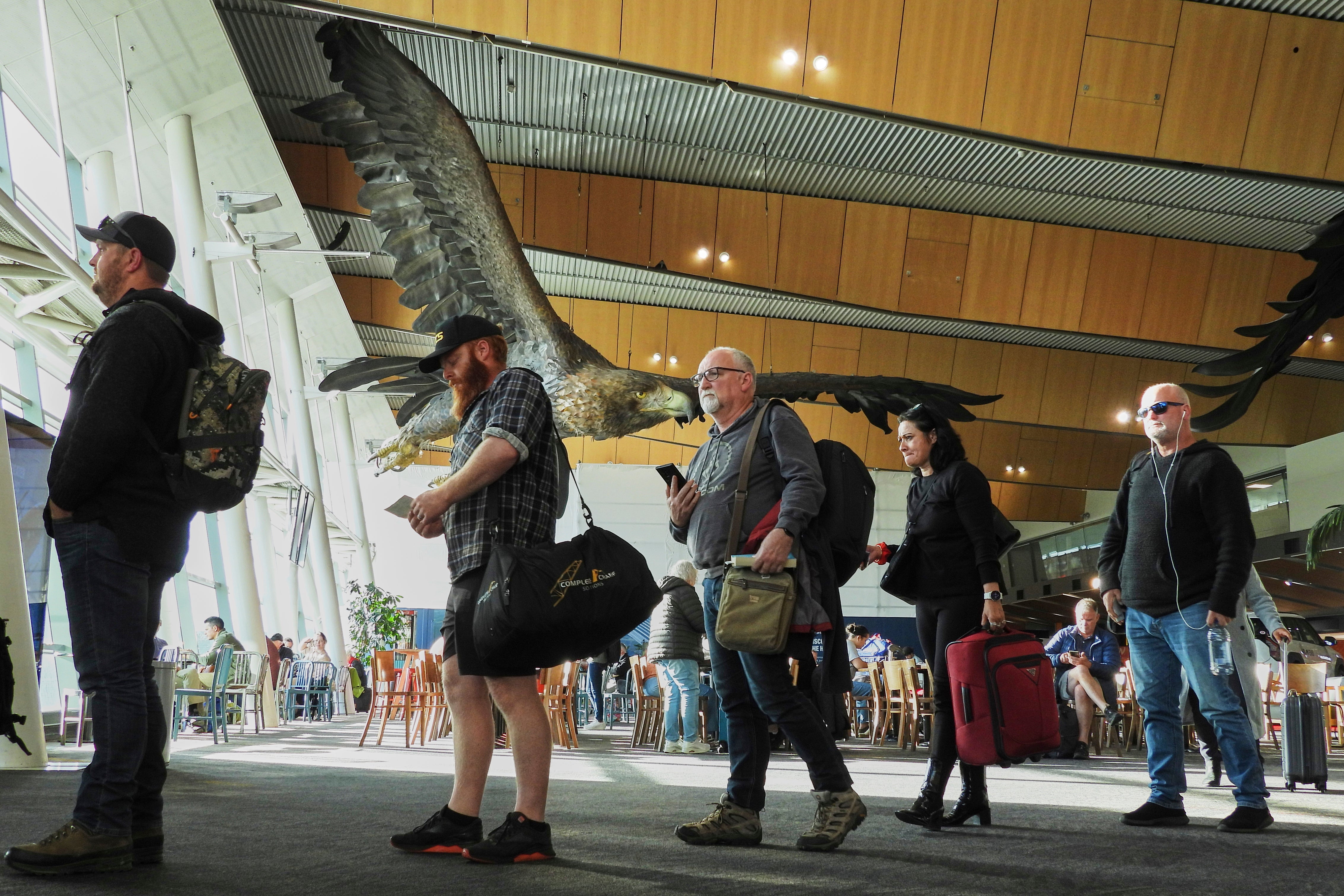 Passengers wait to board a flight at Wellington Airport below the sculpture of an eagle from the Hobbit films, in Wellington, New Zealand, Monday, May 5, 2025. (AP Photo/Charlotte Graham-McLay)
