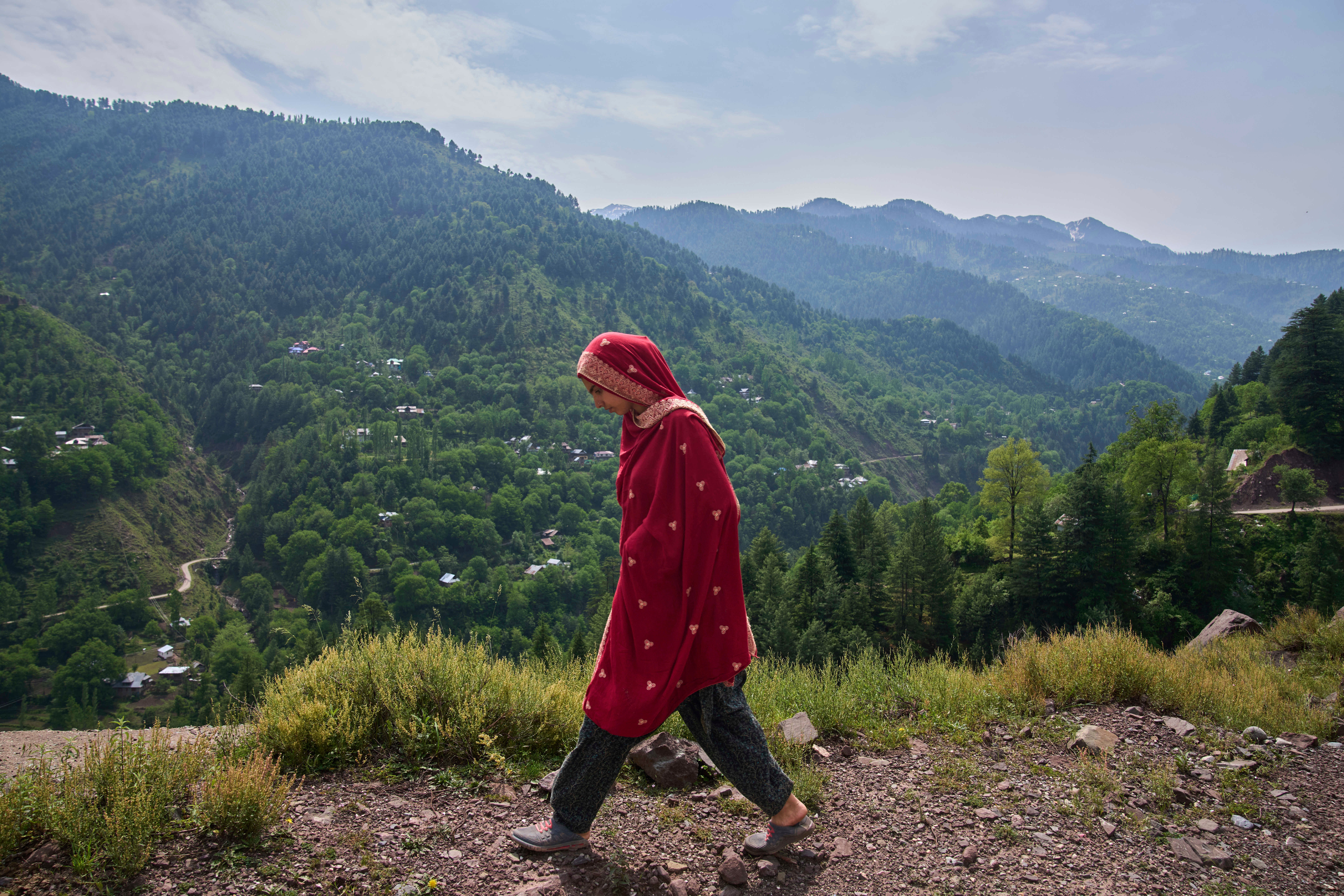A Kashmiri woman walks towards her home at Tilawari village near the Line of Control in Indian-administered Kashmir