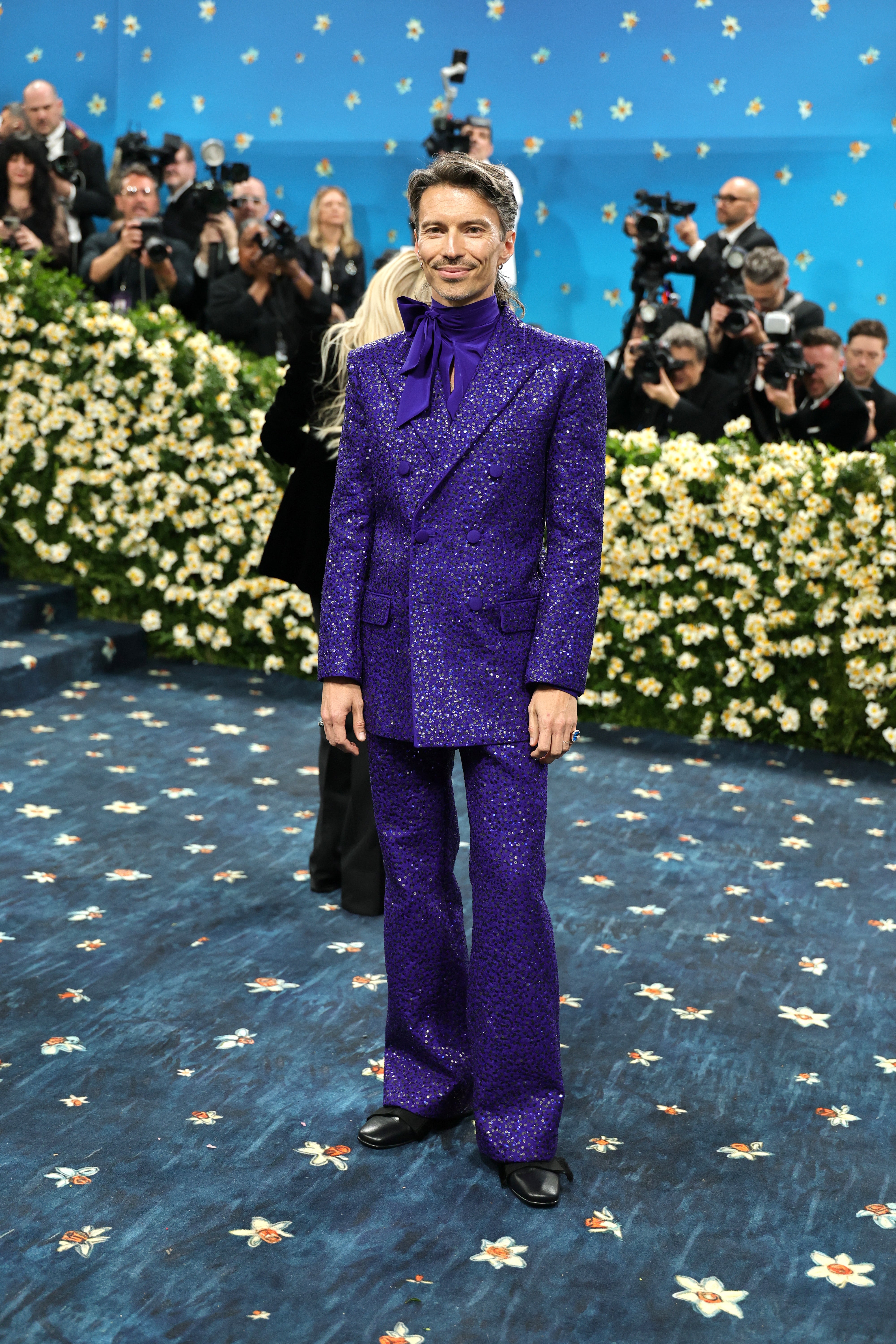 Raúl Domingo, husband of Met Gala co-chair Colman Domingo, wore a glitter purple tuxedo and a matching silk shirt with a bow by Valentino. Domingo also opted for small hoop earrings and statement rings