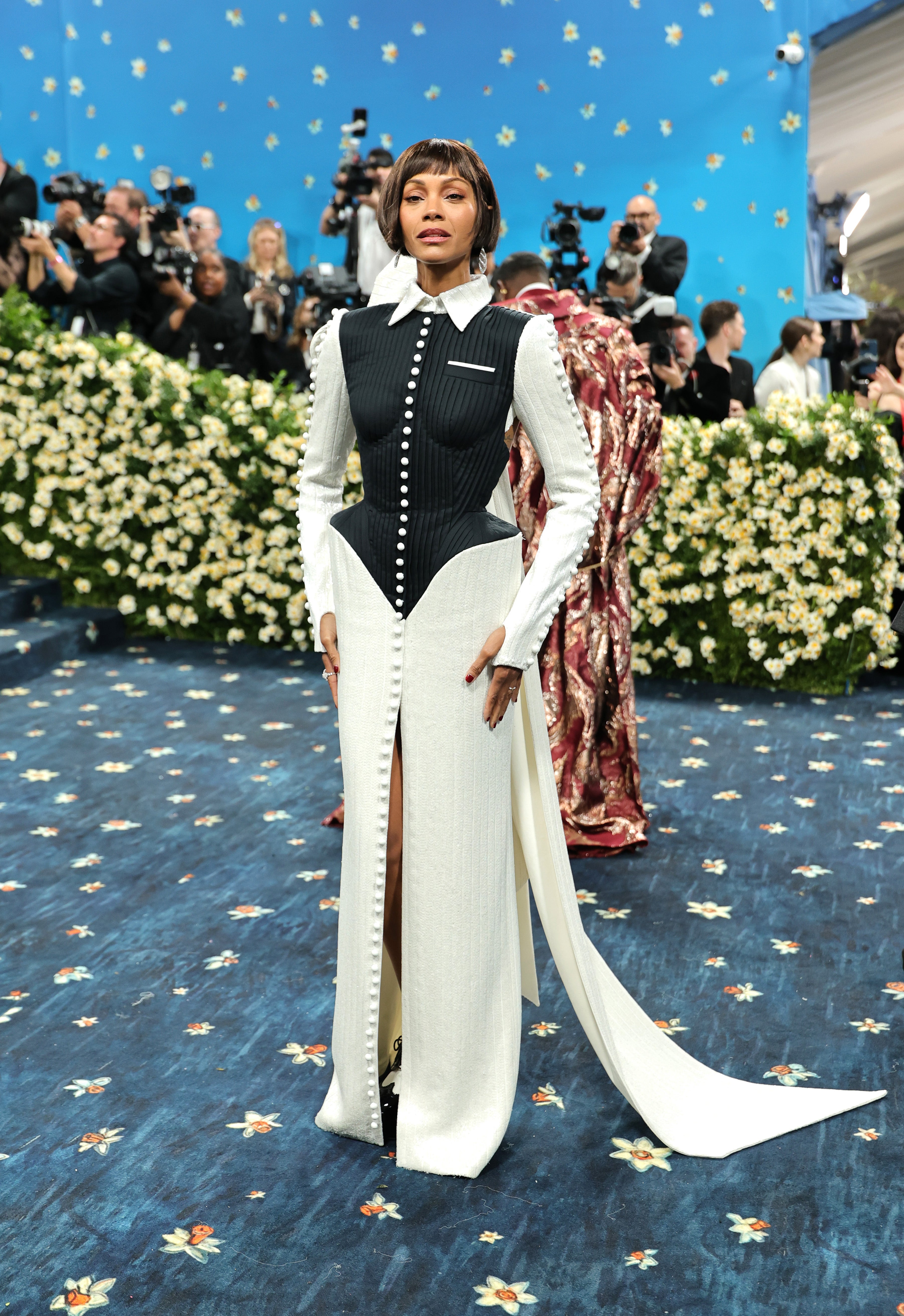 Zoe Saldaña wore a white dress with a slit and black vest top. Her look, which came with a white collar, was adorned with buttons