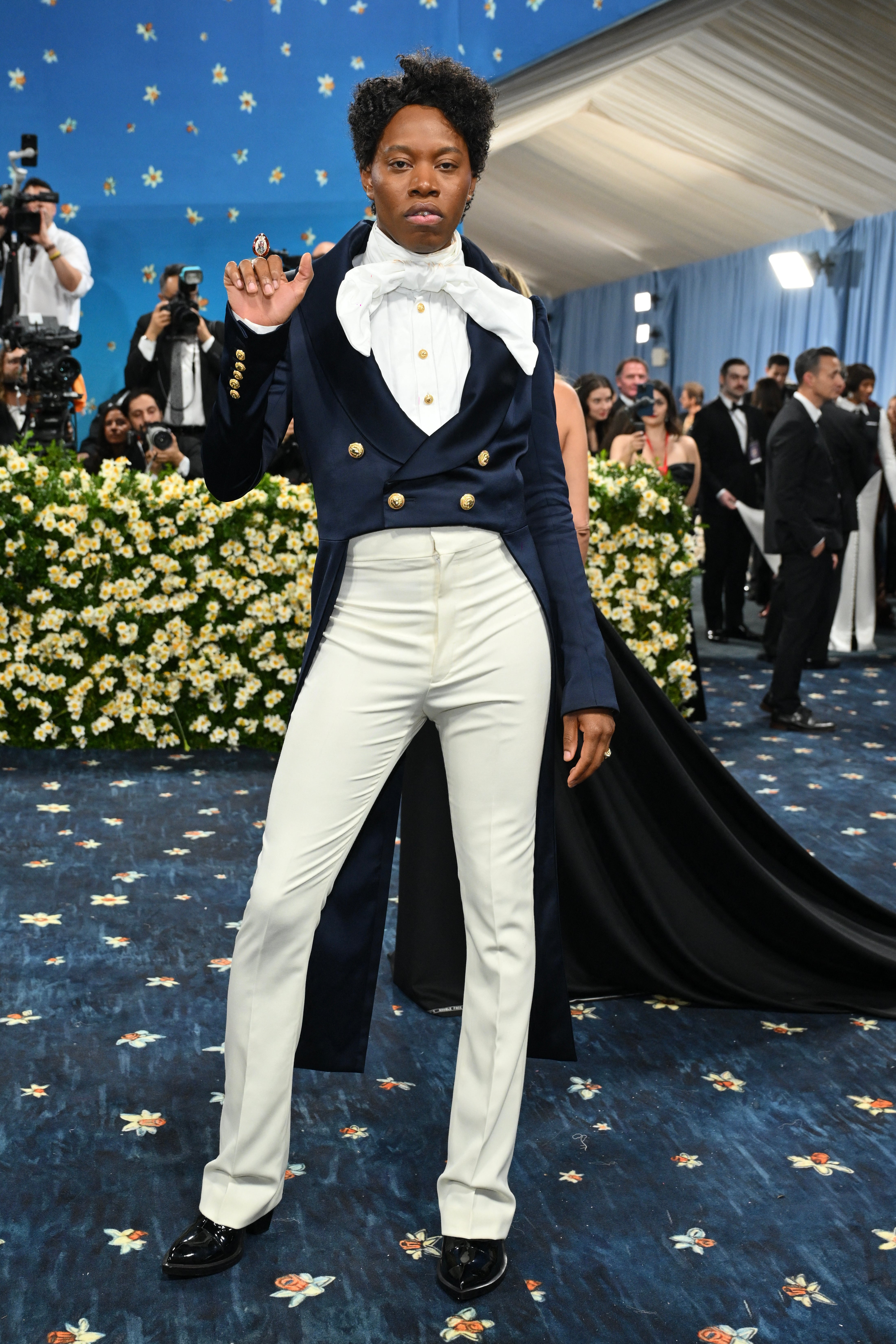 Playwright Jeremy O. Harris wore a cropped navy blue blazer with gold buttons. The blazer, which also came with a train, was complemented with beige pants and a white shirt with a bow