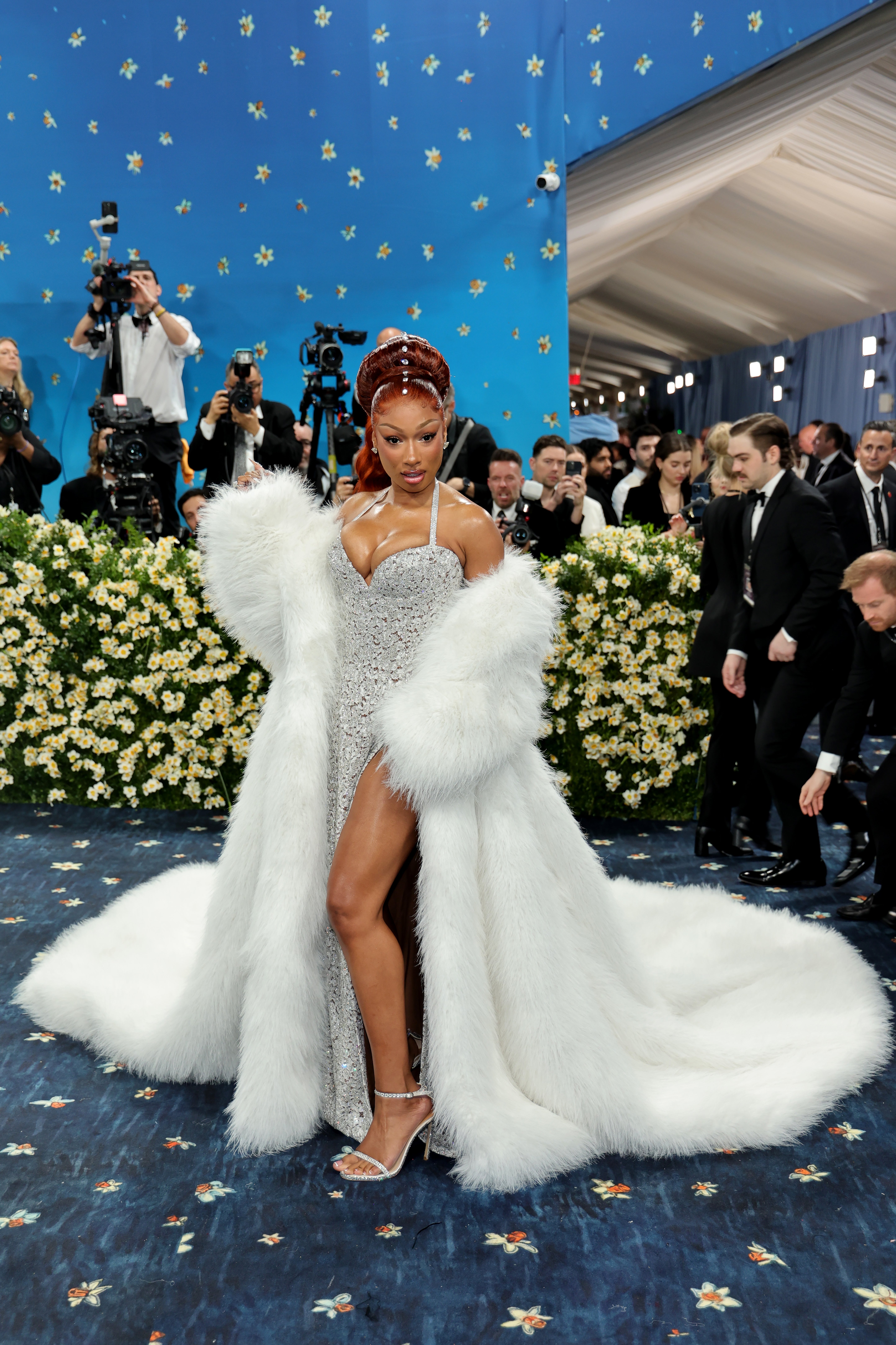 Megan Thee Stallion stepped in front of the cameras on the Met steps in an extravagant outfit comprised of a fluffy white overcoat and a shimmering halter-neck gown with a high slit