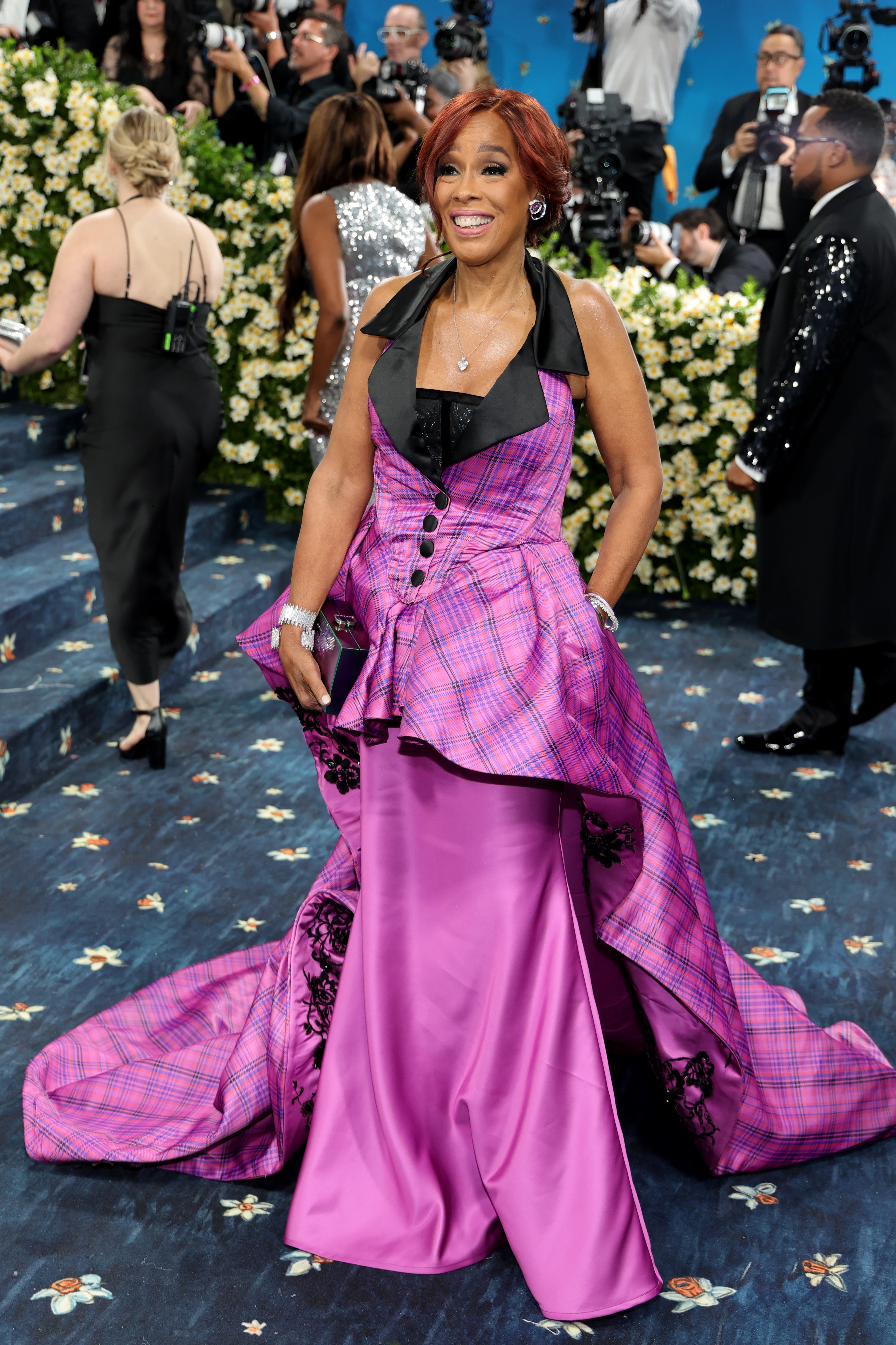 Gayle King posed in front of the cameras on the Met steps for the 2025 fundraiser in a pink plaid dress with a long train stitched over a slim skirt