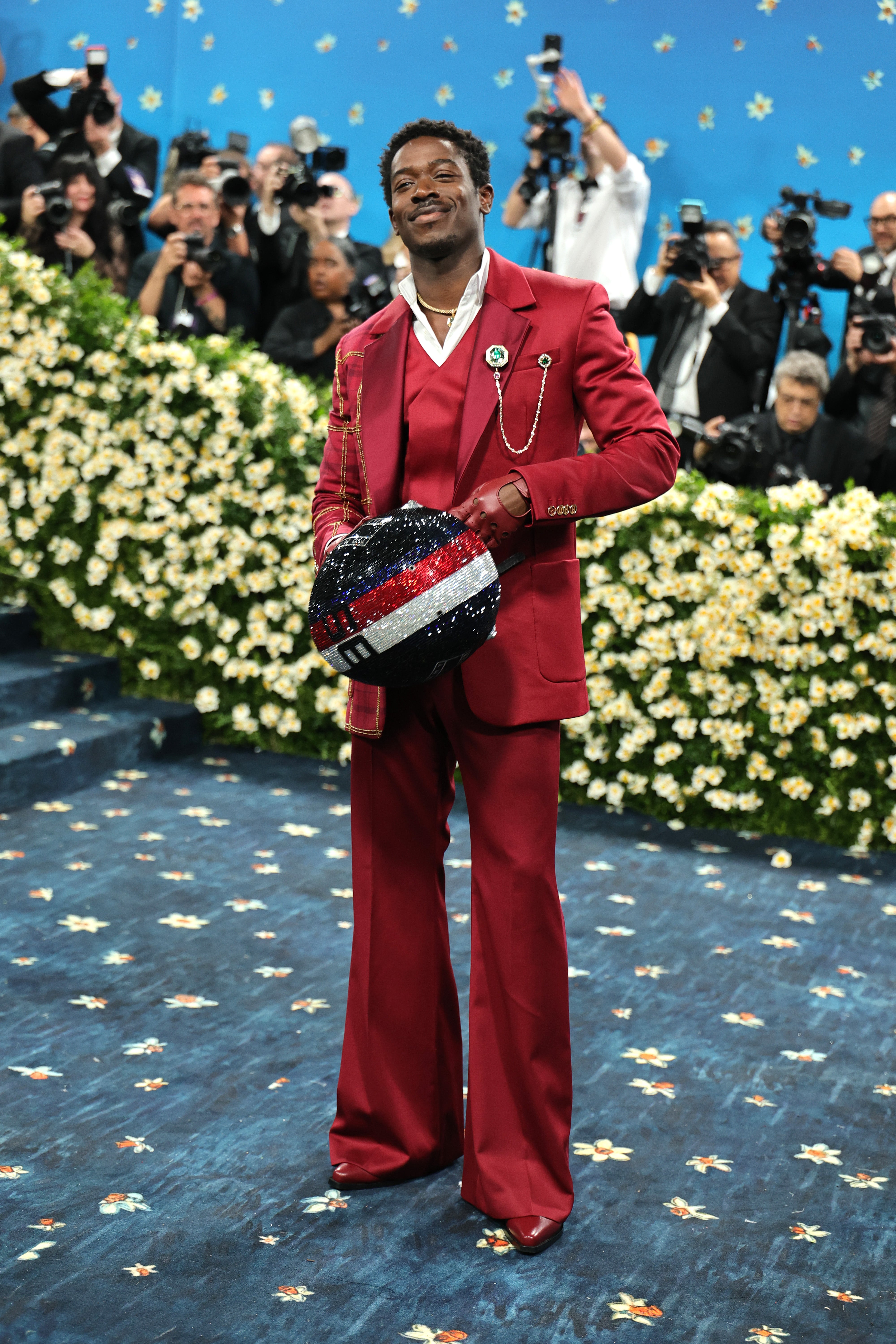 However, Idris's racing set and helmet were removed on the blue carpet, revealing his satin red tuxedo, which also featured a white collar