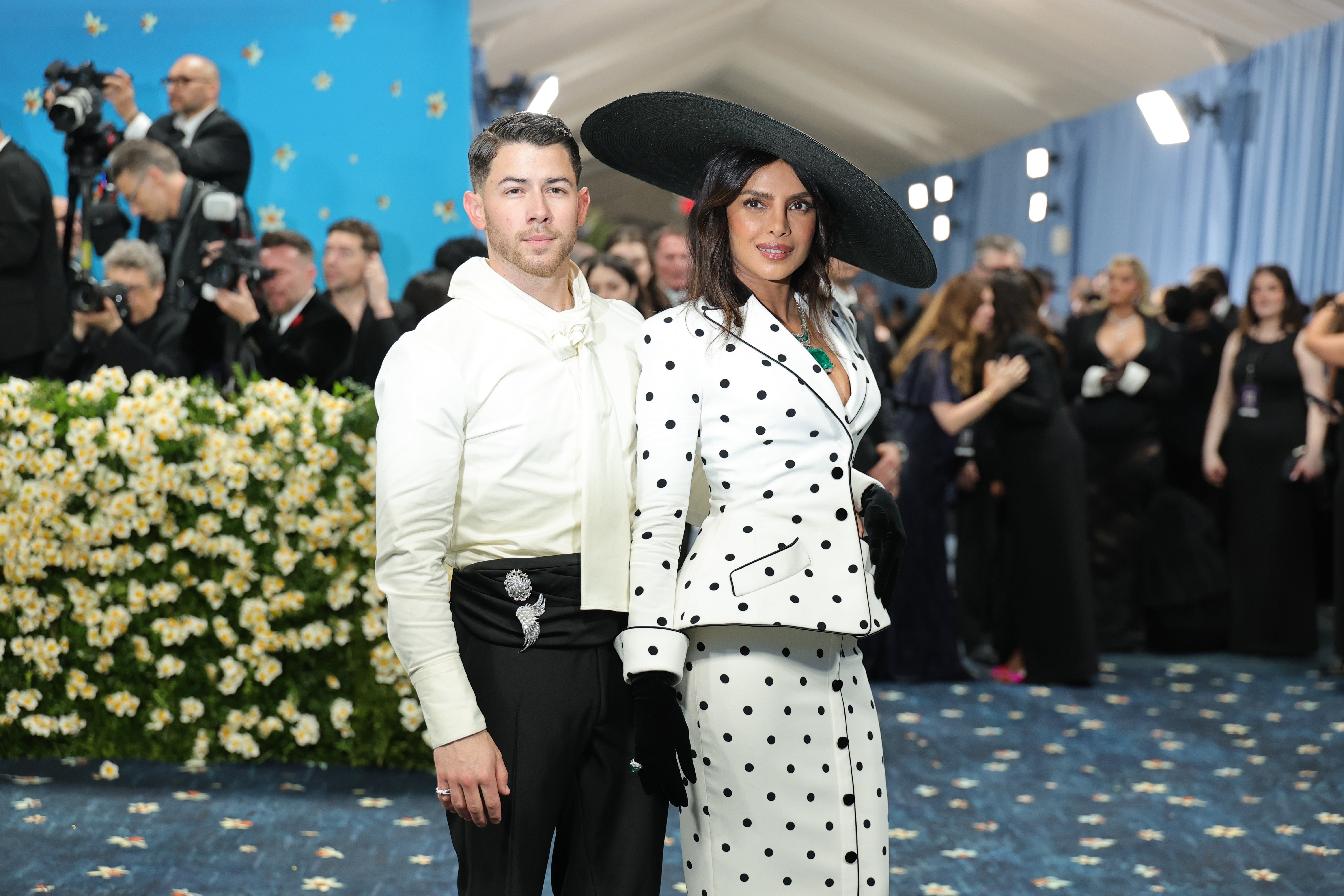 The musician wore an ivory shirt with a pussy bow and black pants with a black cummerbund. Chopra, on the other hand, donned a polka-dotted two-piece blazer and skirt set with black gloves and a wide-brimmed hat secured on the side of her head