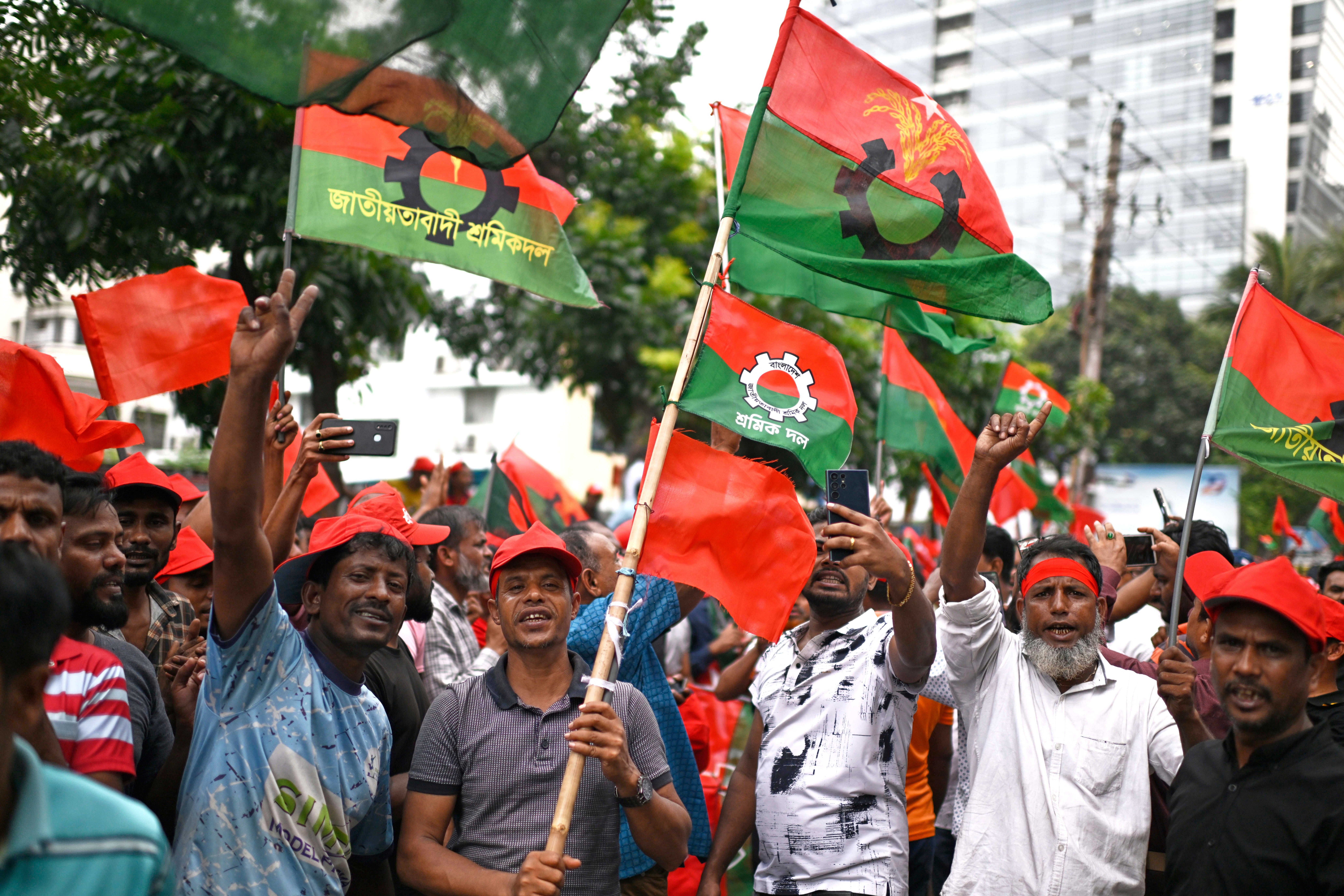 Supporters of Bangladesh's former prime minister Khaleda Zia wave their party flags as they await her arrival from London at the airport in Dhaka on 6 May 2025