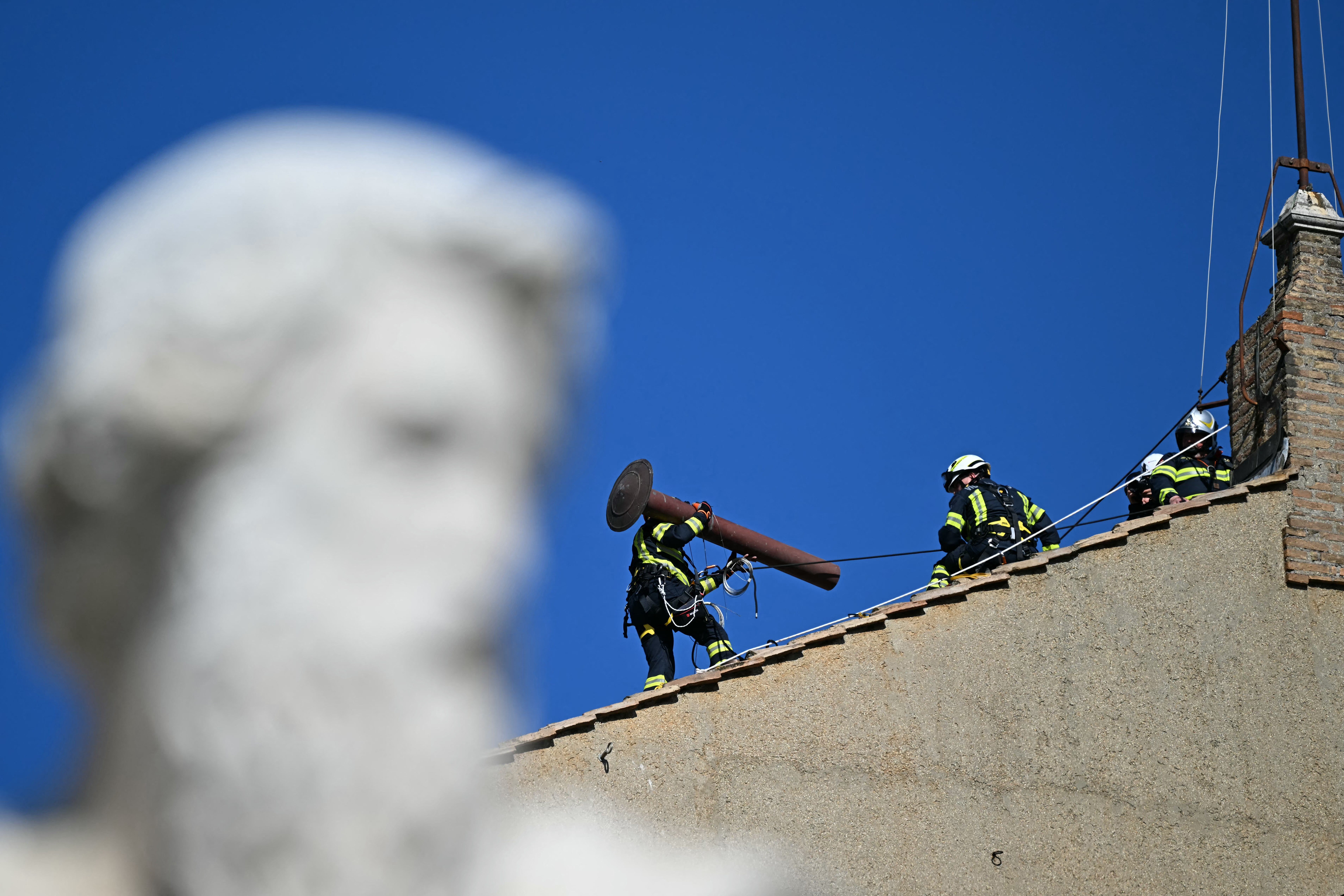 Workers install the chimney on the roof of the Sistine Chapel on May 2