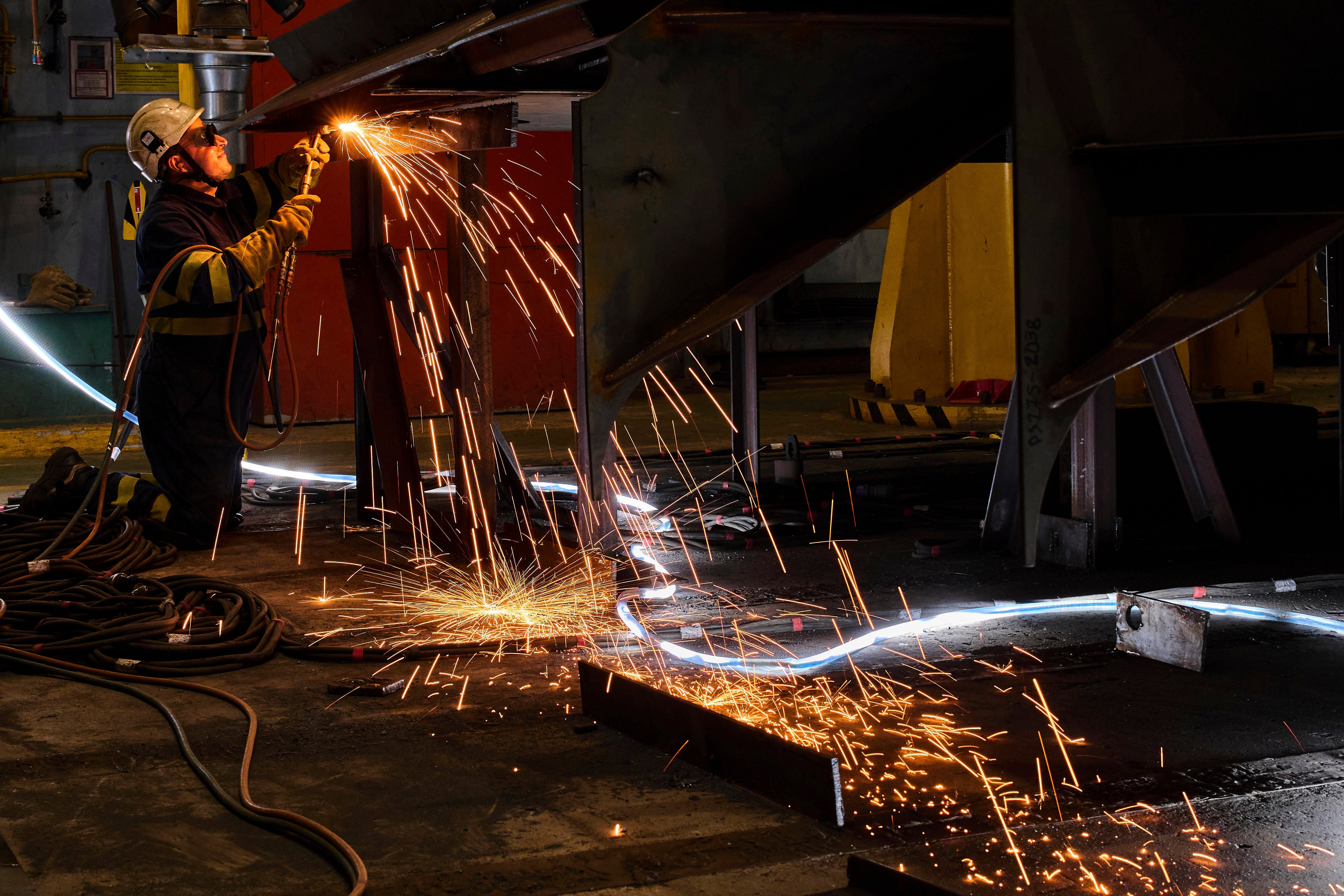 A worker welds a section of the F-111 class frigate's fuselage at a workshop in the Navantia shipyard in Ferrol, northwest Spain,