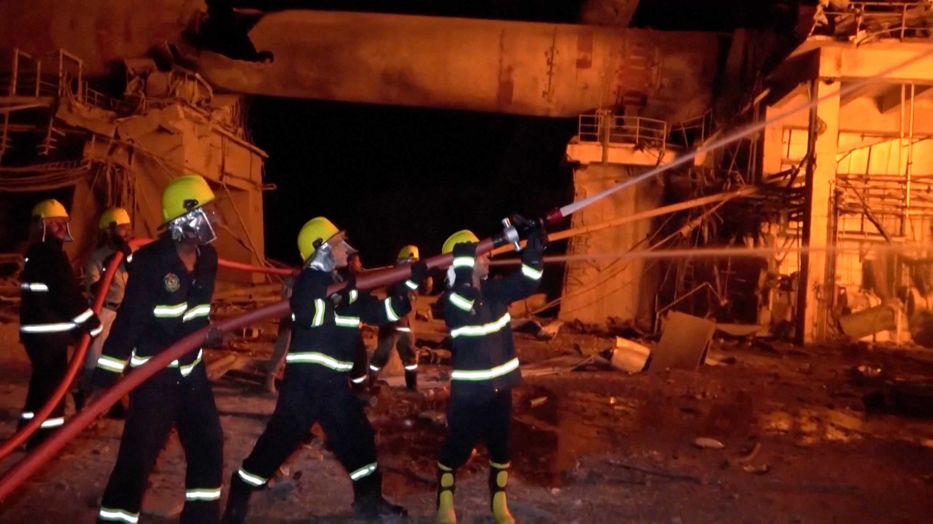 Firefighters spray water to put out a fire caused by an Israeli attack on a cement factory near Hodeidah port in Yemen