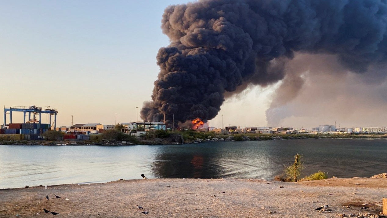 A view shows a large plume of smoke and fire rising from fuel depot in Port Sudan