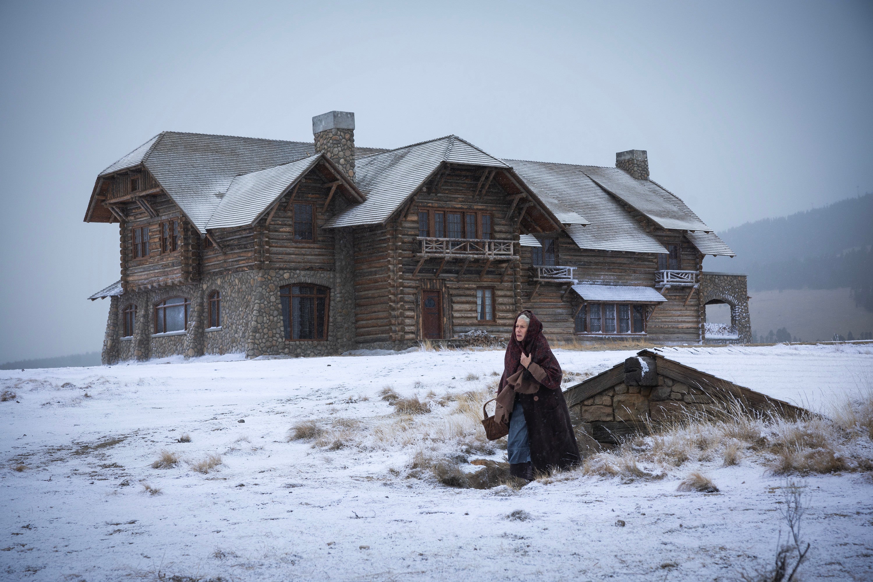 Helen Mirren as Cara Dutton in 1923 standing outside the ranch’s lodge