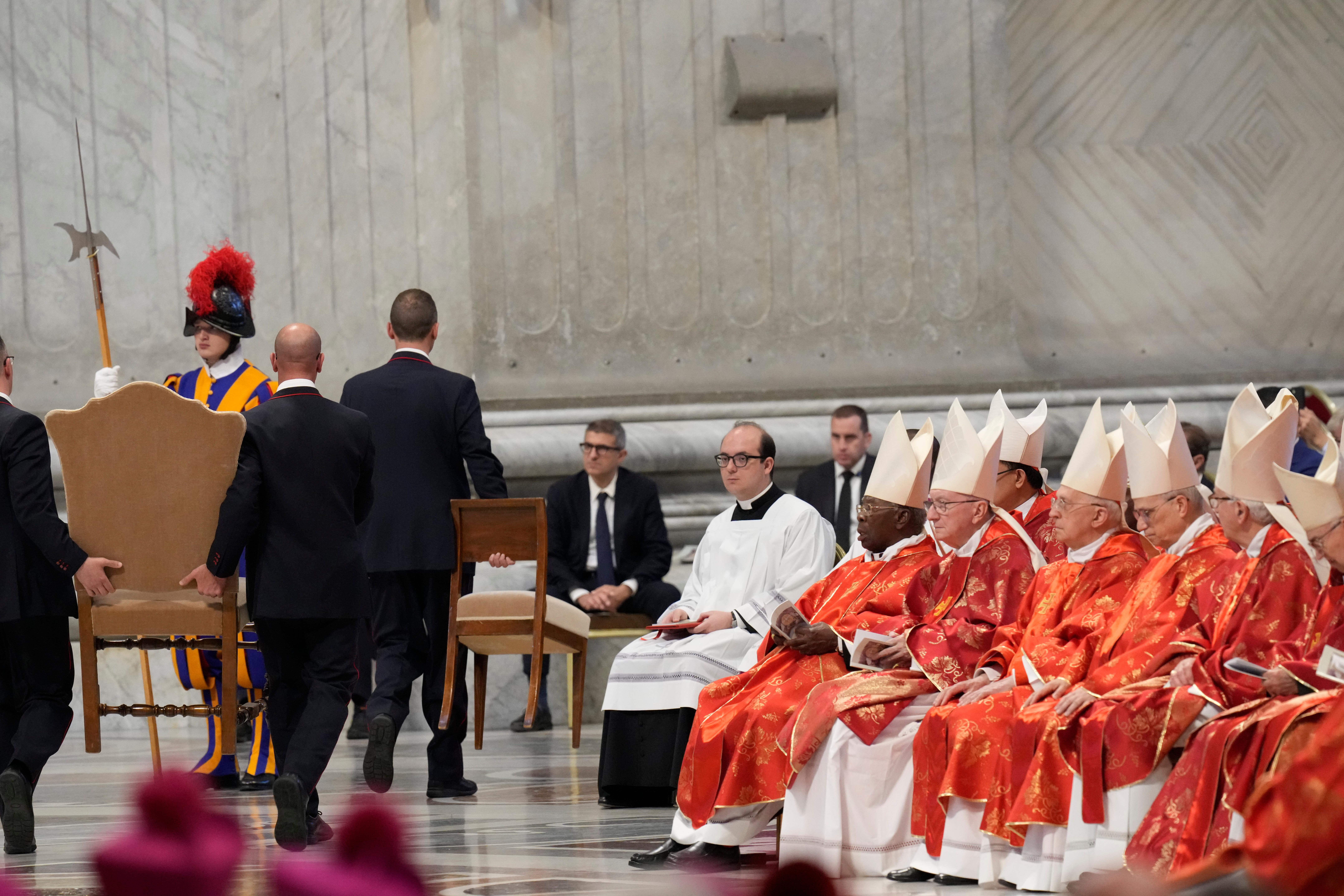 A chair is taken away at the end of a final mass celebrated by cardinals inside St Peter’s Basilica, before the conclave to elect a new pope (Gregorio Borgia/AP)