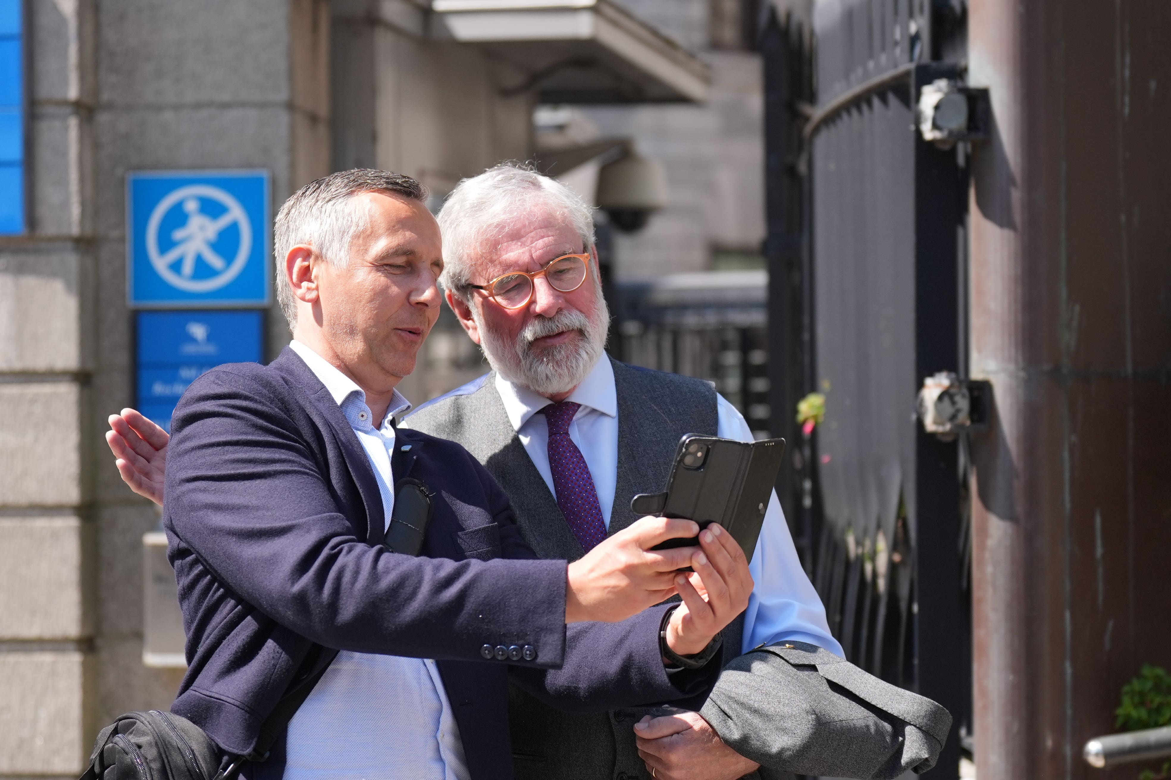 Former Sinn Fein president Gerry Adams poses for a photograph with a member of the public outside the High Court in Dublin (Niall Carson/PA)