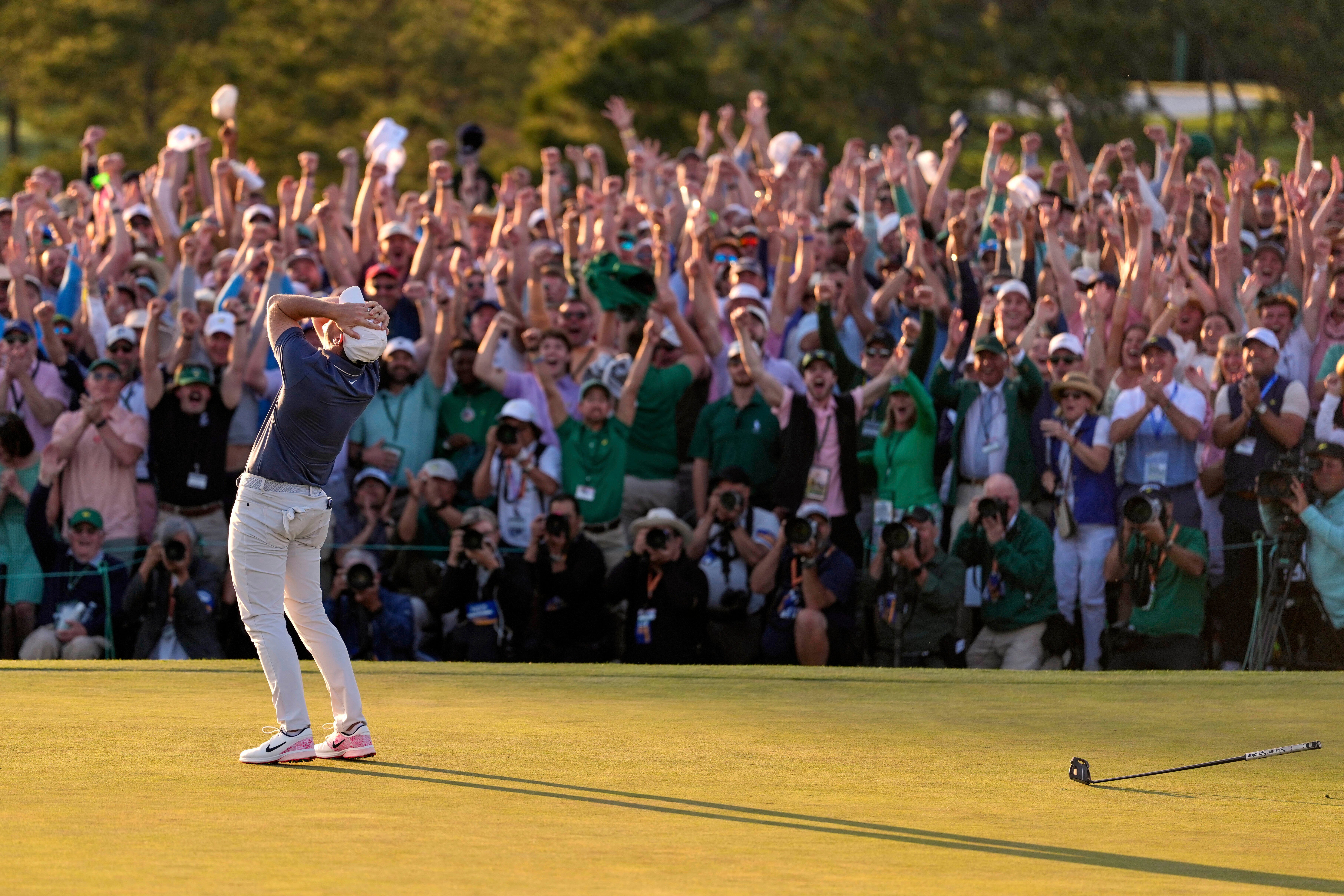 The crowd cheers as Rory McIlroy celebrates winning the Masters with a birdie on the first play-off hole