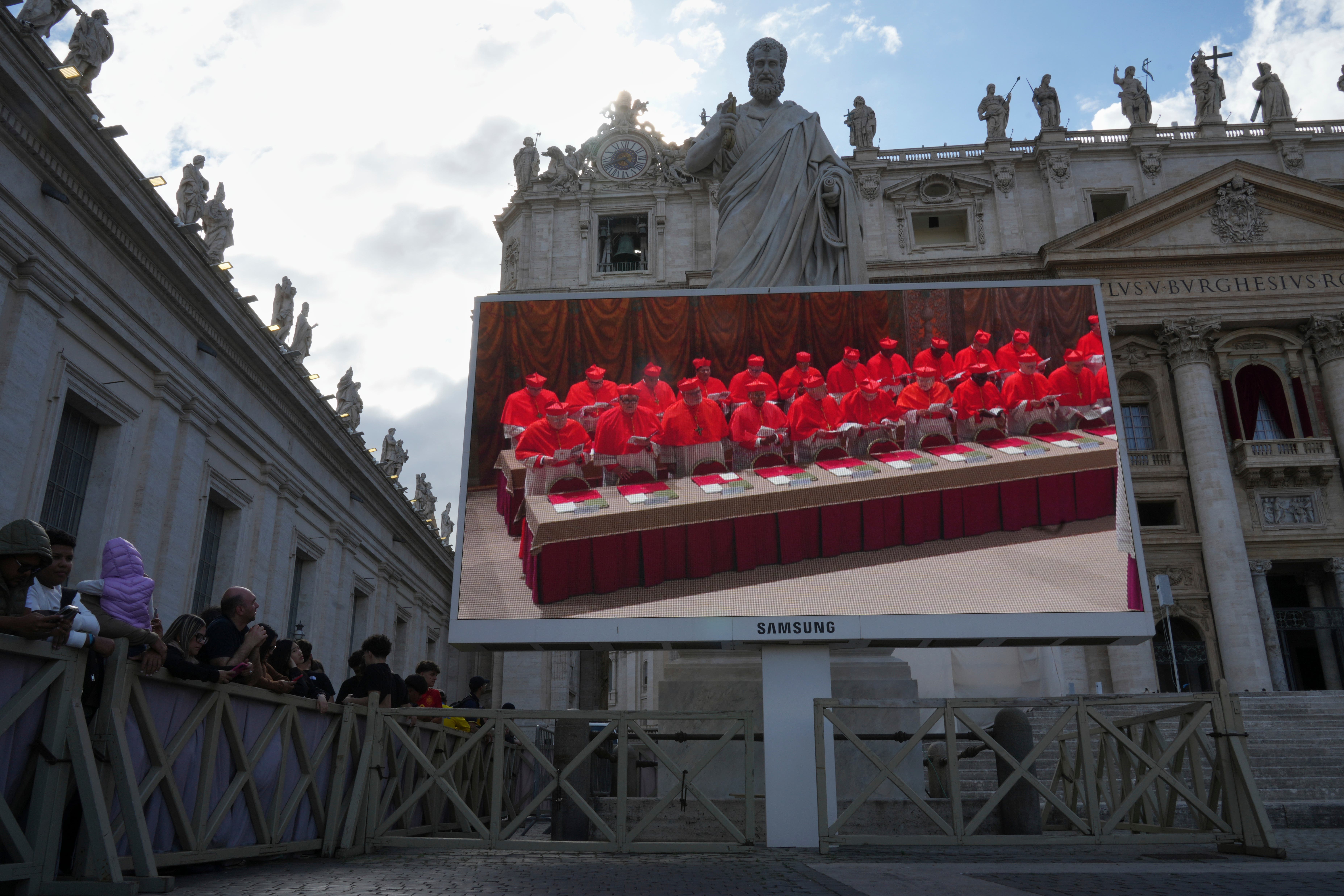 A giant screen in St Peter’s Basilica shows cardinals inside the Sistine Chapel during the conclave (Alessandra Tarantino/AP)