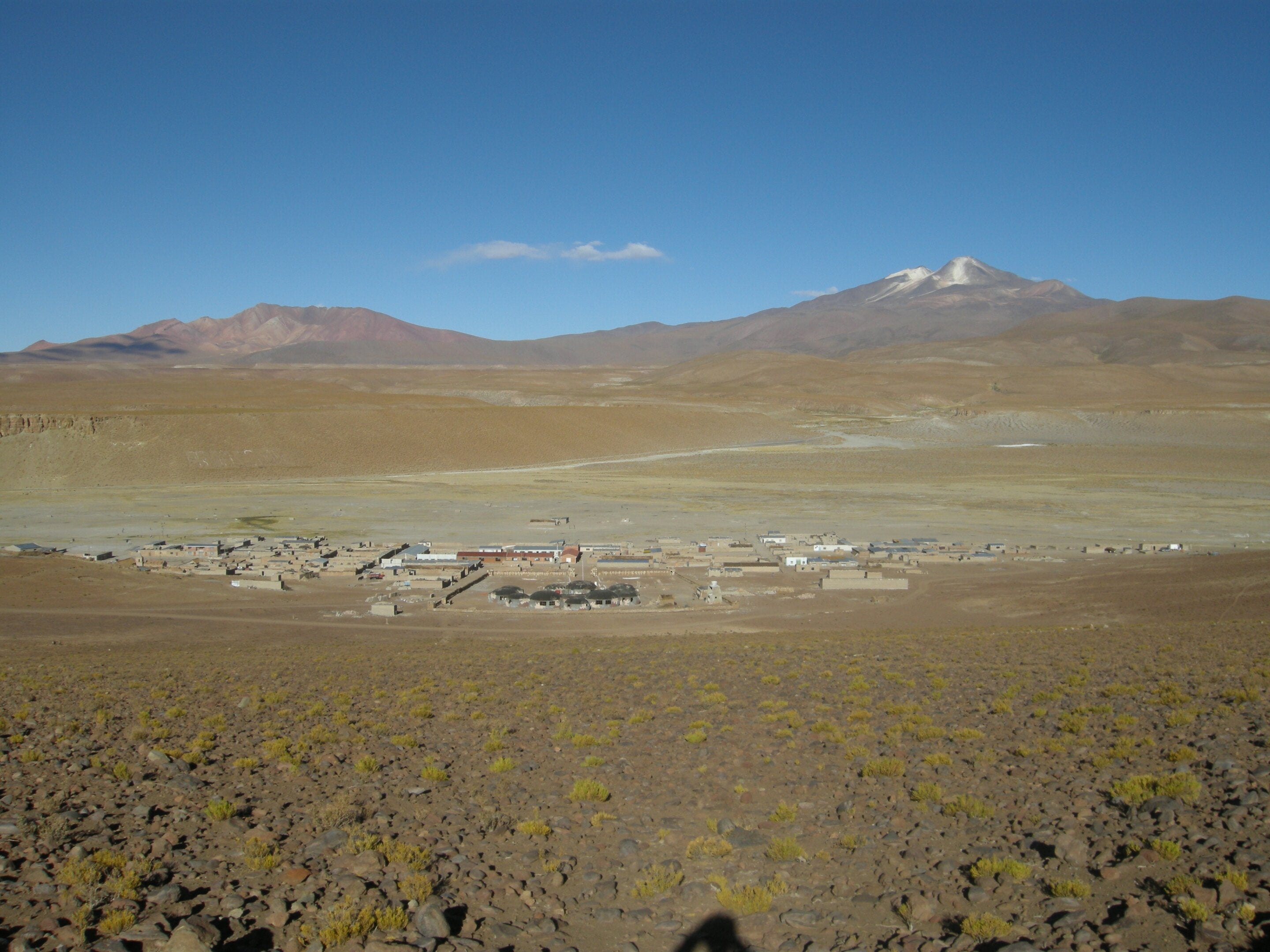 Cerro Uturuncu, right, and Cerro San Antonio volcanoes rise above the small town of Quetena Chico in Bolivia