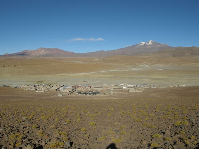 <p>Cerro Uturuncu, right, and Cerro San Antonio, volcanoes rise above the town of Quetena Chico in Bolivia</p>