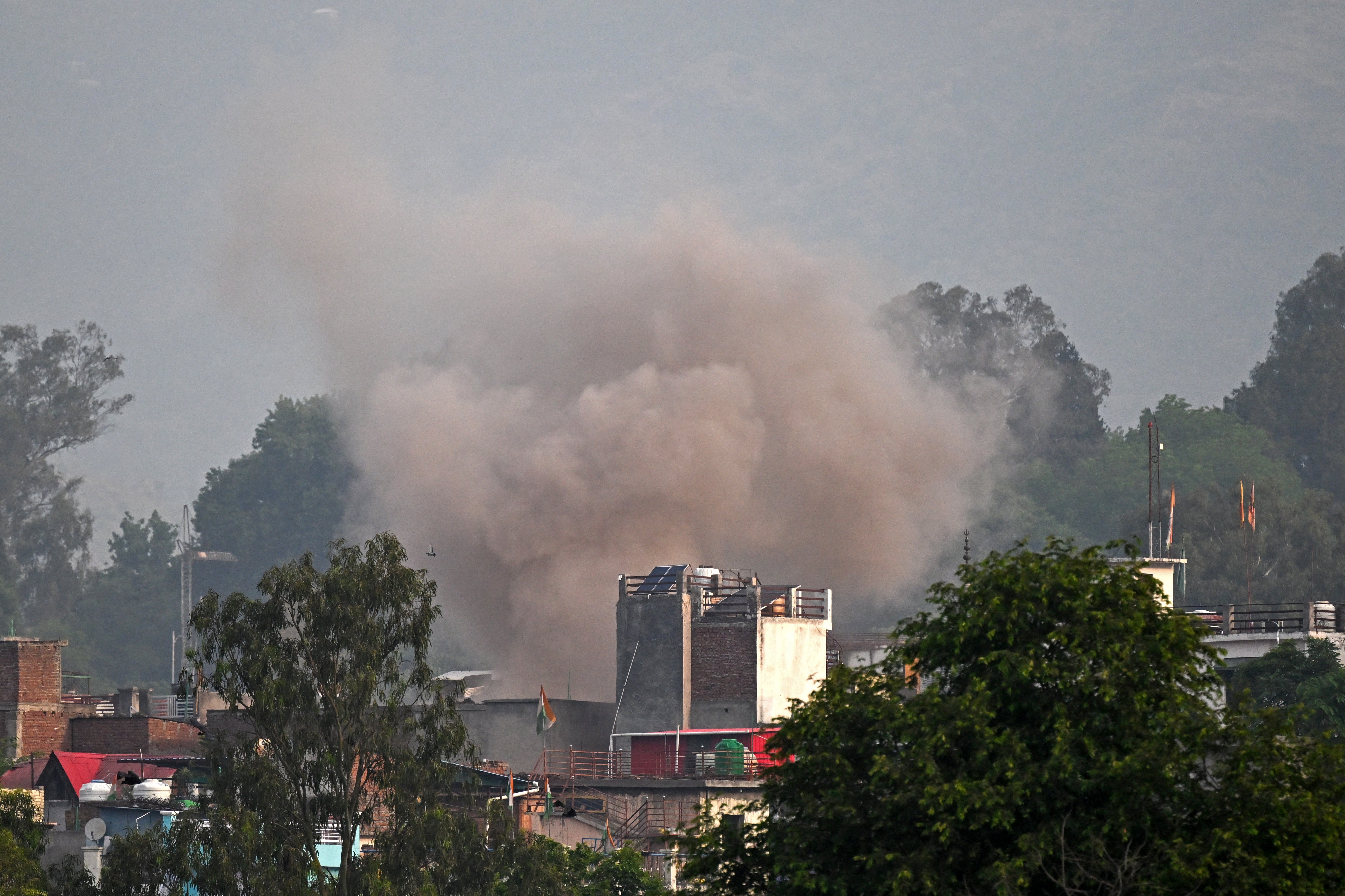 Smoke billows after an artillery shell landed in the main town of Poonch district in India's Jammu region on 7 May 2025