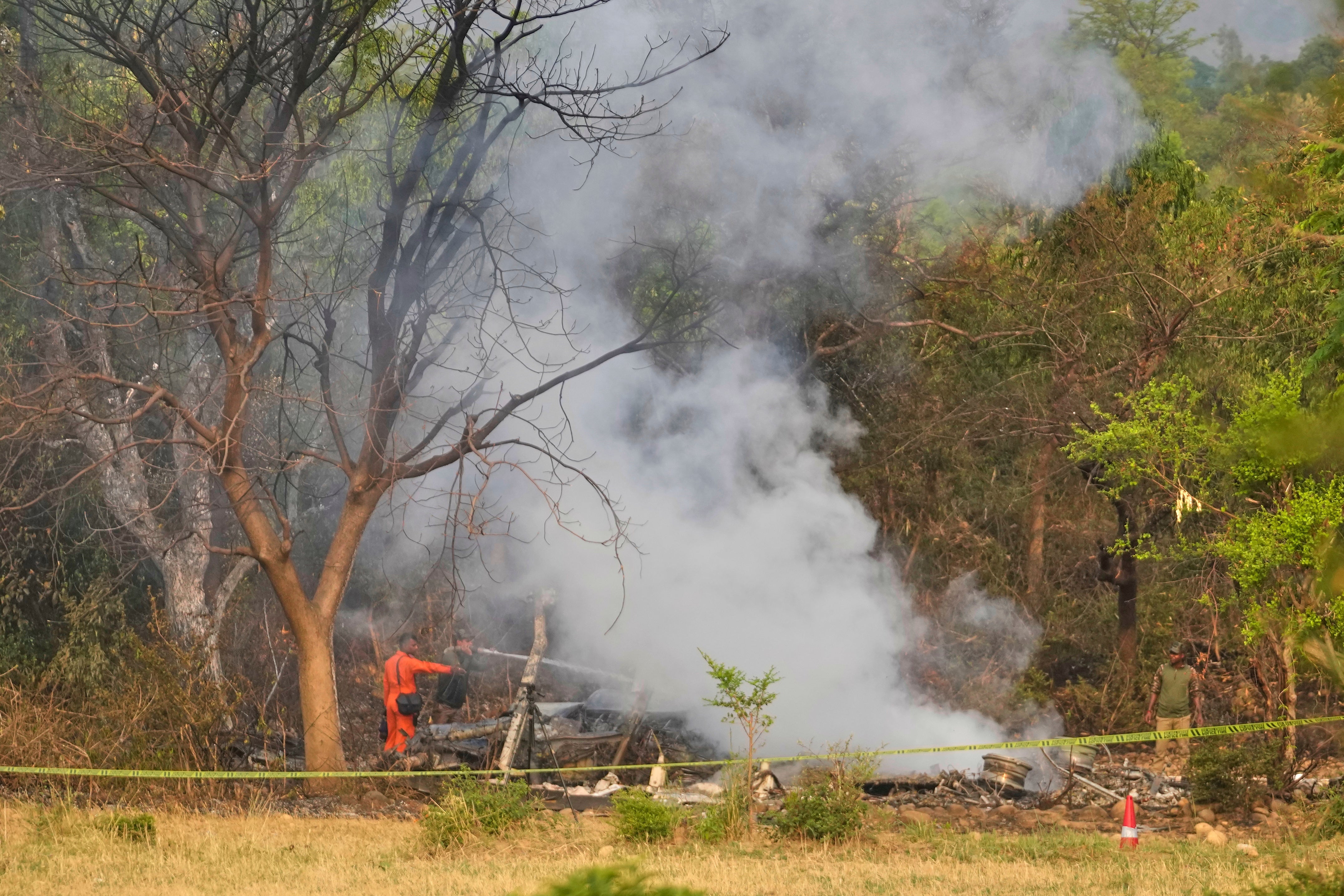 Fire fighters douse smoke coming out from the debris of an aircraft near Akhnoor on the outskirts of Jammu, India, Wednesday, 7 May 2025