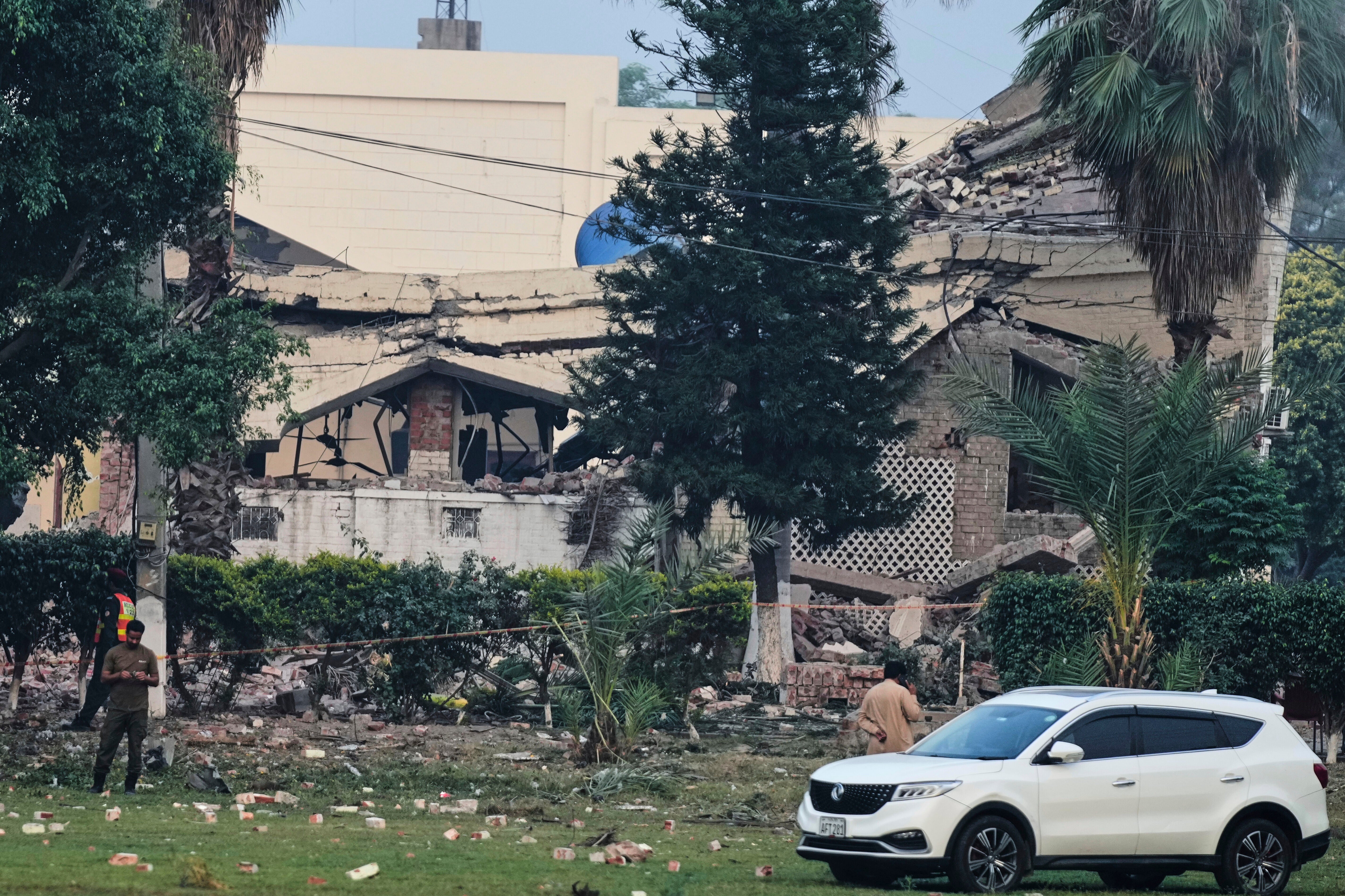 A police officer and rescue workers stand at the site of a suspected Indian missile attack, in Muridke, a town in Pakistan's Punjab province, Wednesday, 7 May 2025