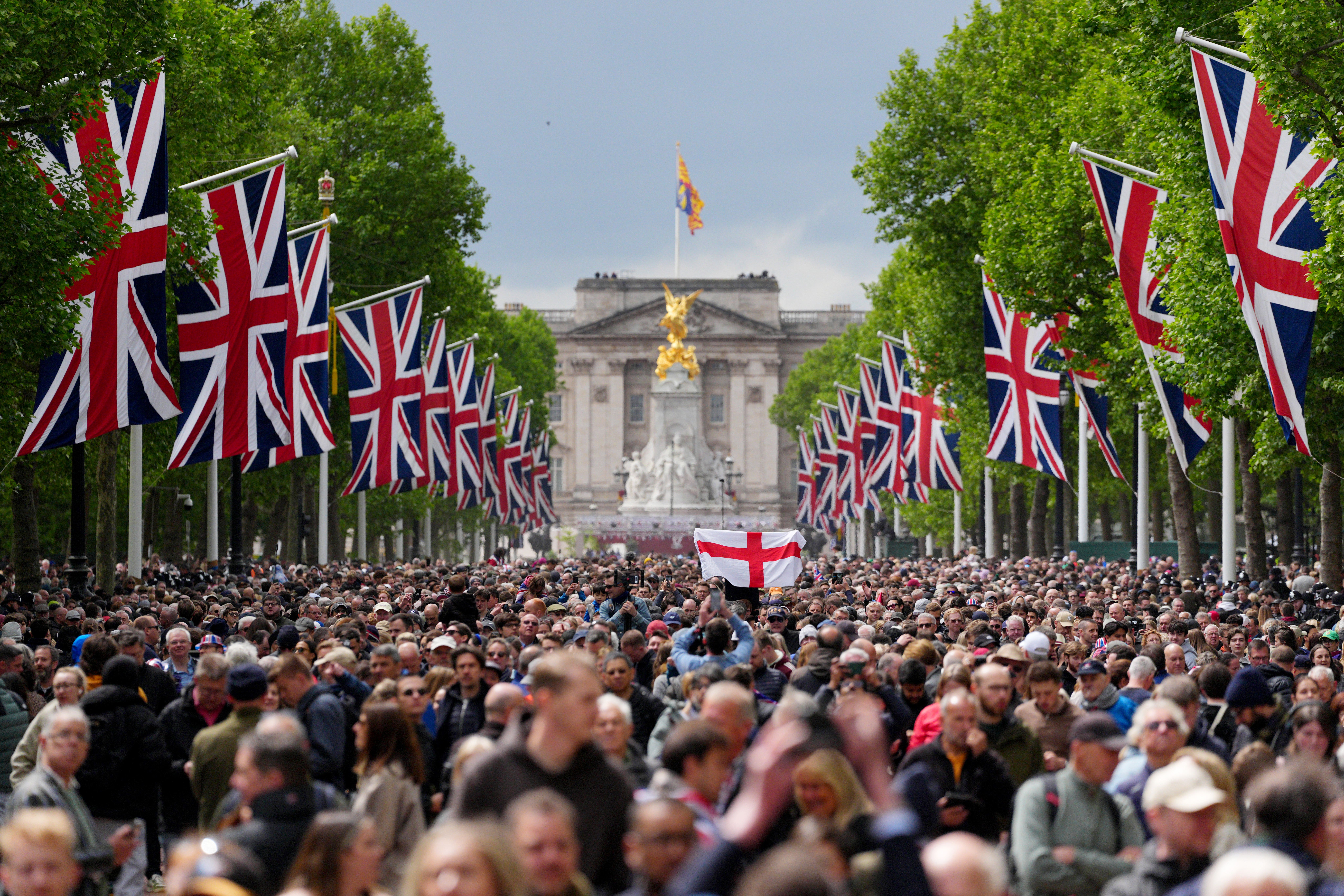 Members of the public along The Mall watch the flypast following the military procession to mark the 80th anniversary of VE Day on Monday (Carl Court/PA)