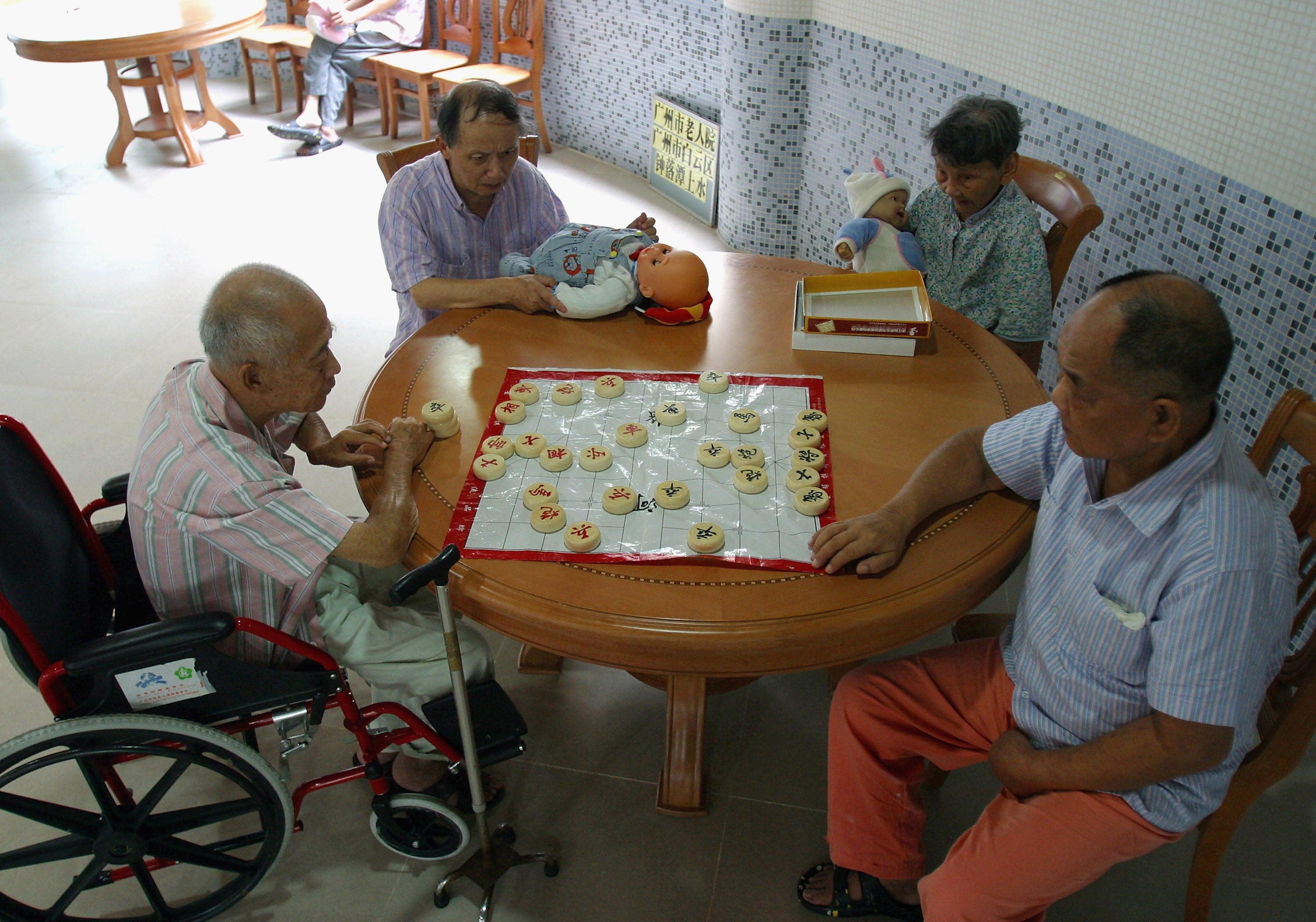 Chinese elders who suffer from senile dementia play chess and dolls as a treatment