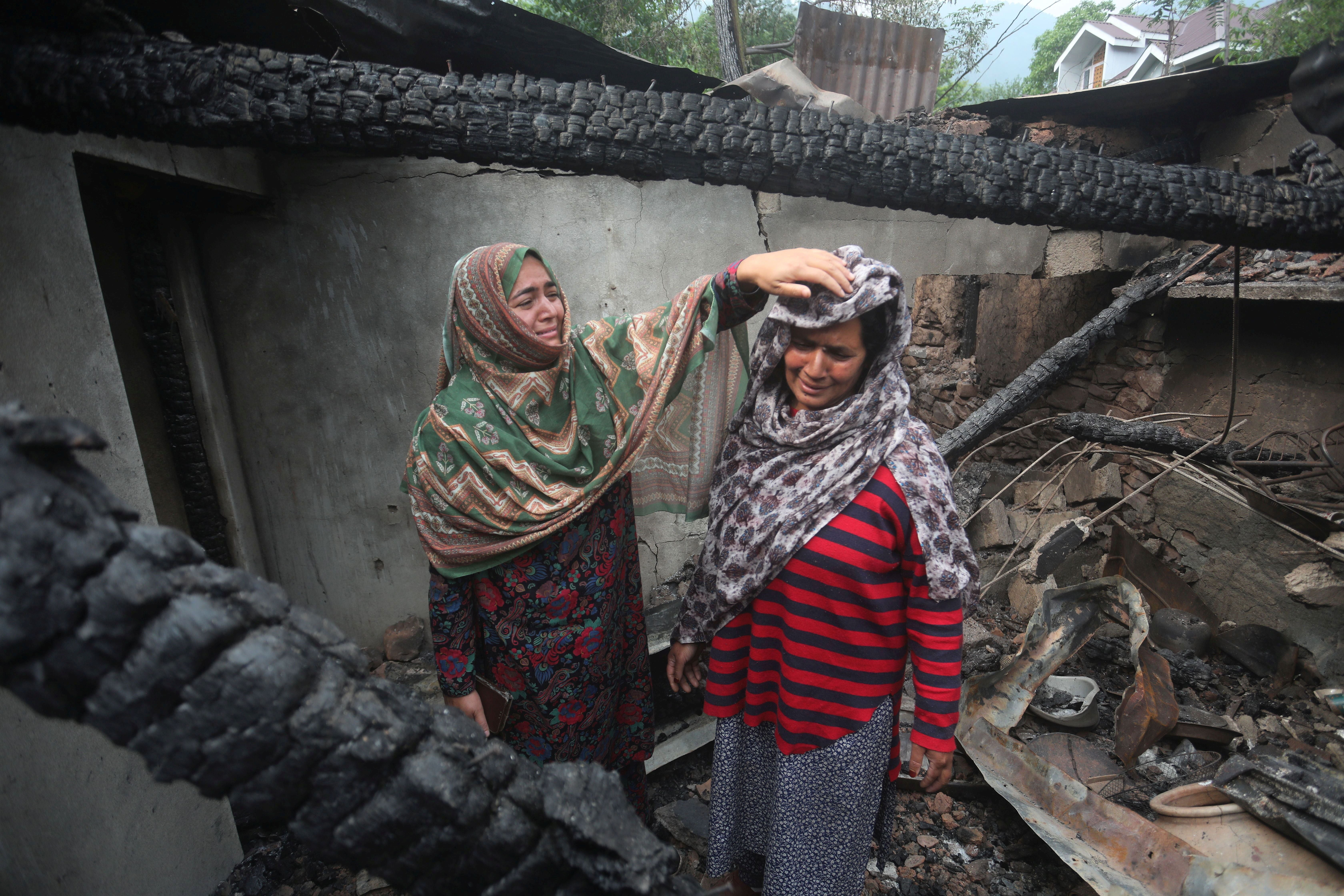 Kashmiri women grieve after their house is damaged by shelling from Pakistan at Salamabad village in Uri, north of Srinagar, Kashmir, on 8 May 2025