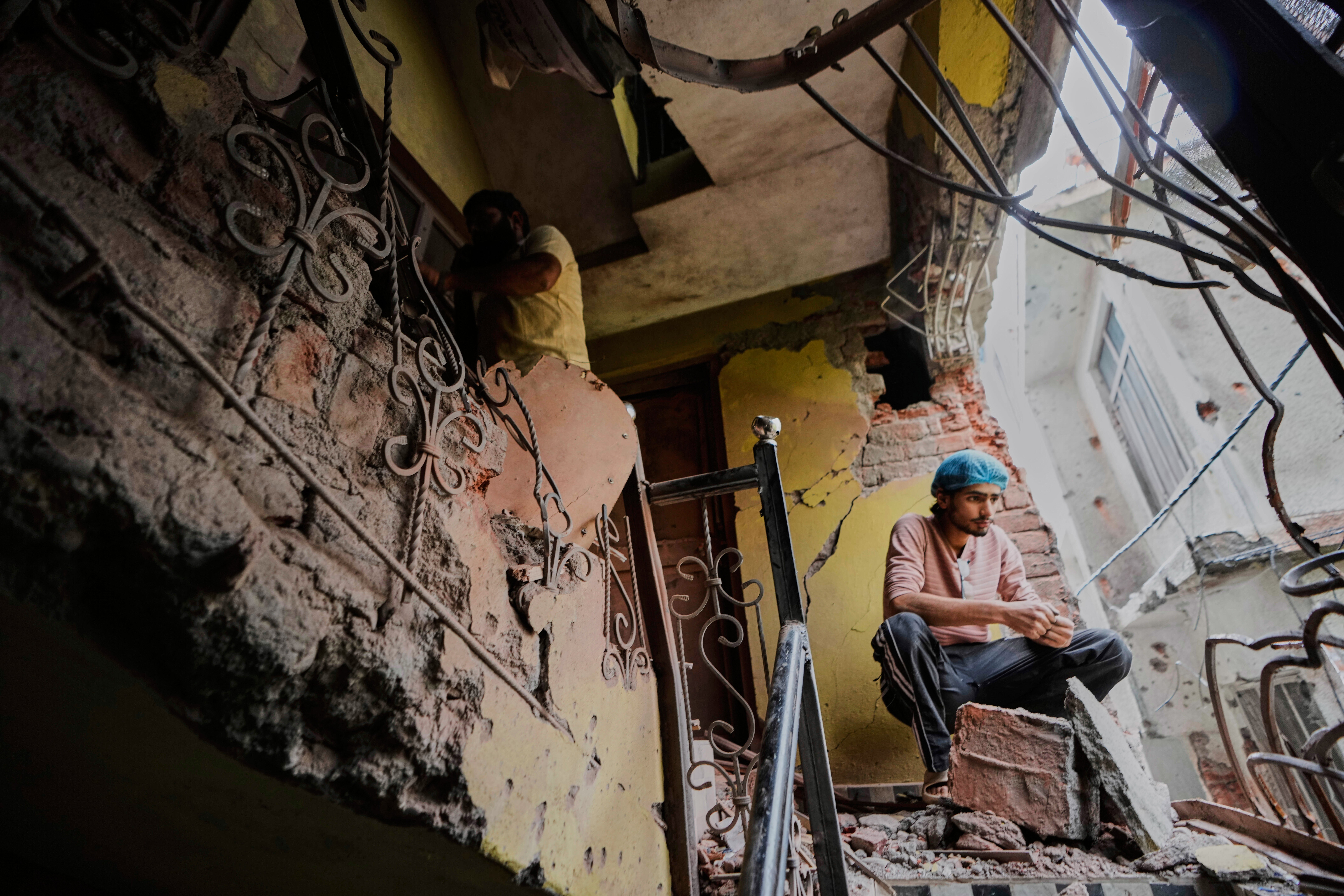 A person sits in his house damaged by Pakistani artillery shelling in Poonch, Kashmir, on 8 May 2025