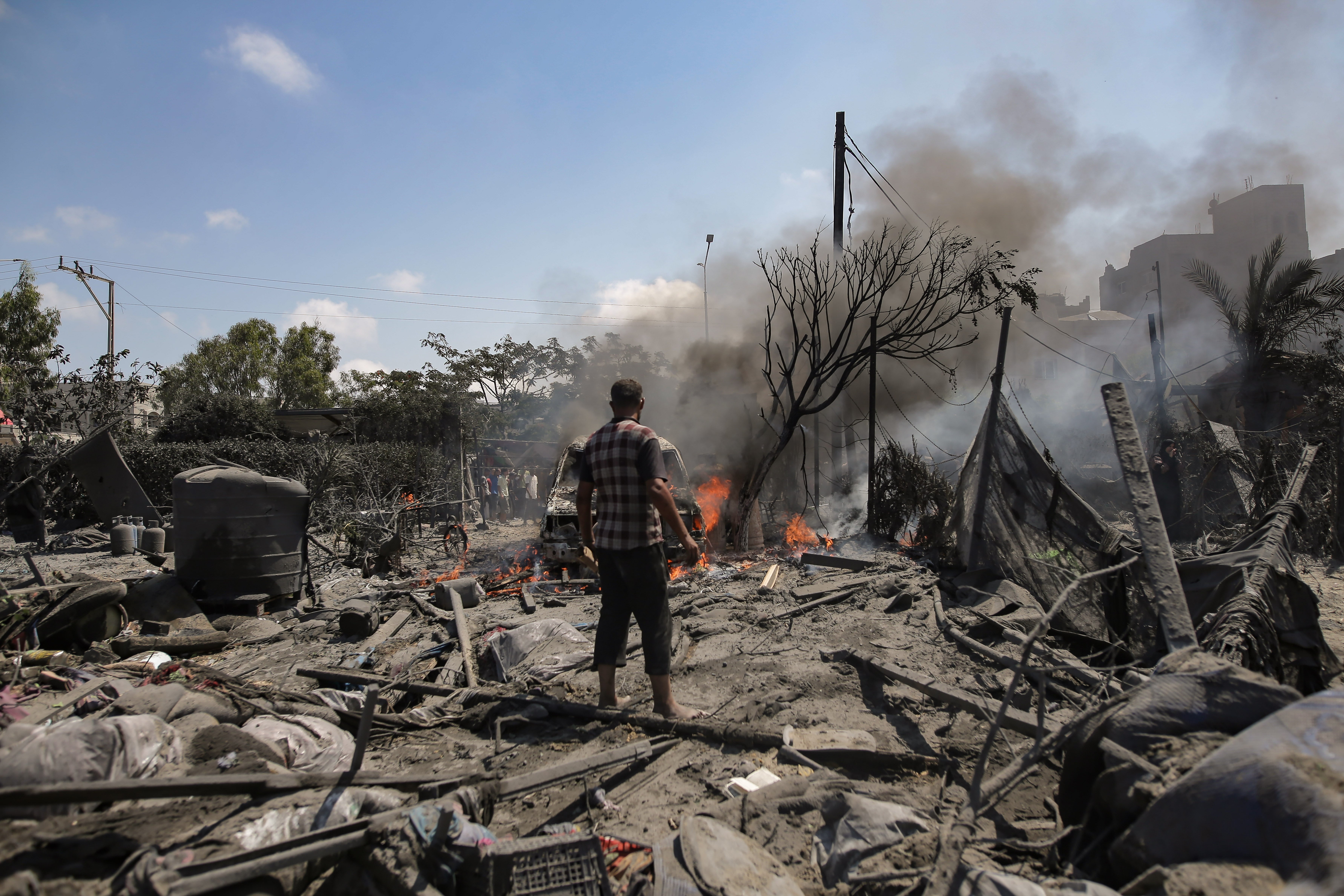 Palestinians inspect the scene after an Israeli raid on the tents of displaced people in the Al-Mawasi area of Khan Yunis in the southern Gaza Strip, 13 July 2024