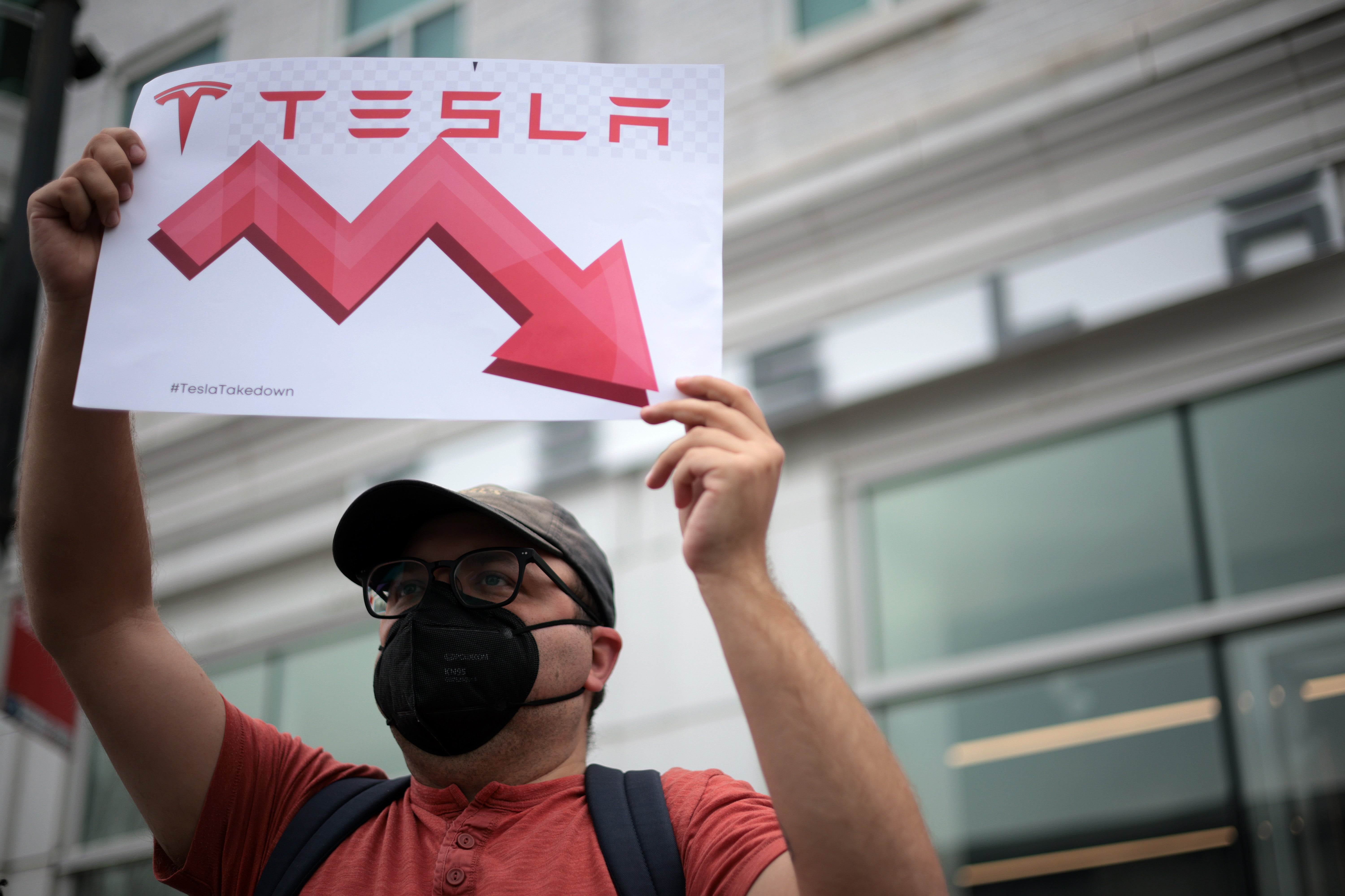 An activist demonstrates outside of a Tesla showroom in Washington, D.C., on March 29 2025