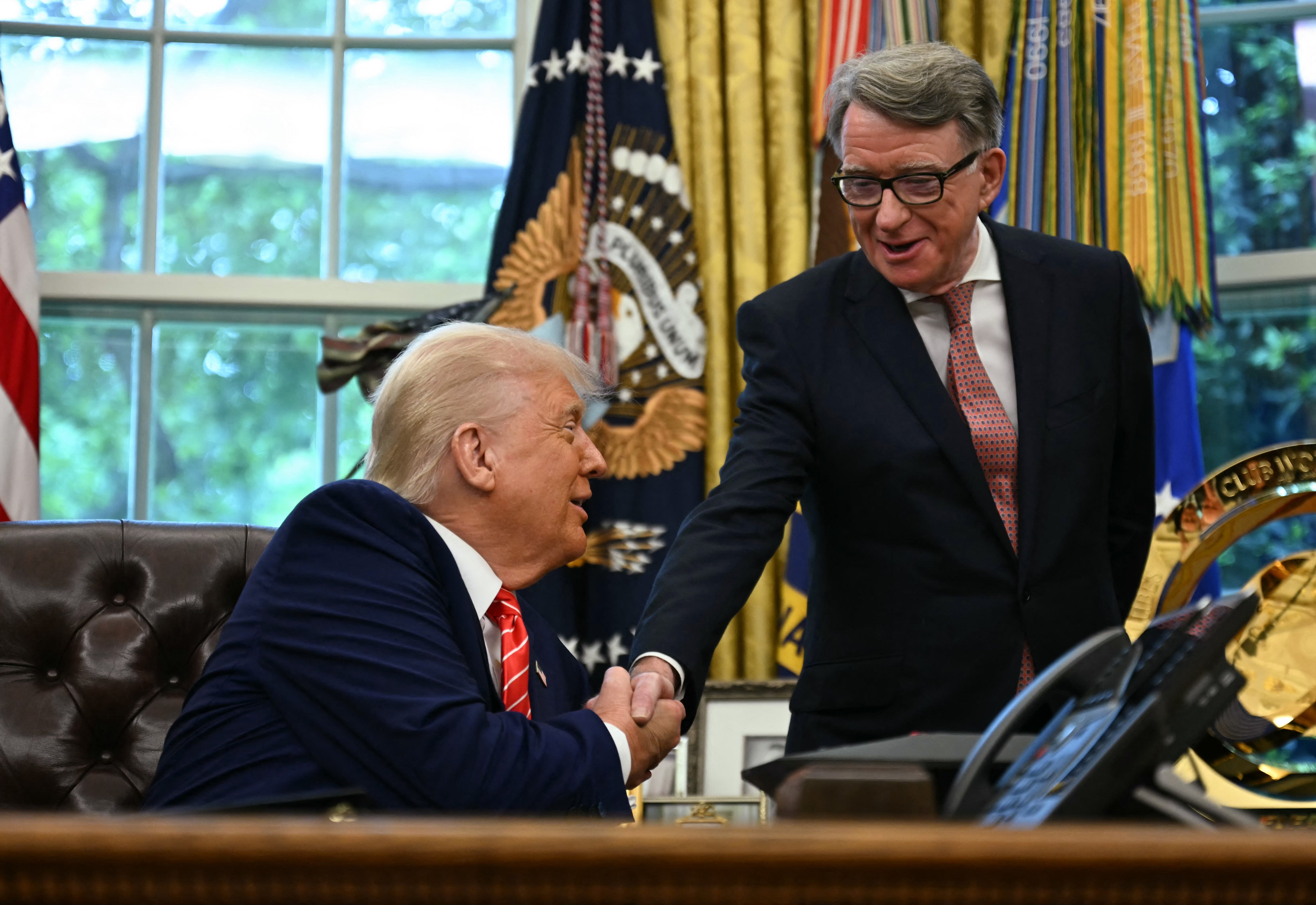 Trump shakes hands with Peter Mandelson, the U.K. ambassador to the U.S., during the press conference to announce the trade deal