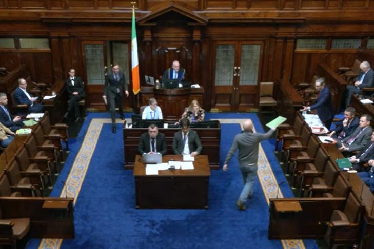 People Before Profit TD Paul Murphy hands Tanaiste Simon Harris a document during Leaders’ Questions on Thursday (Oireachtas TV/Screenshot/PA)