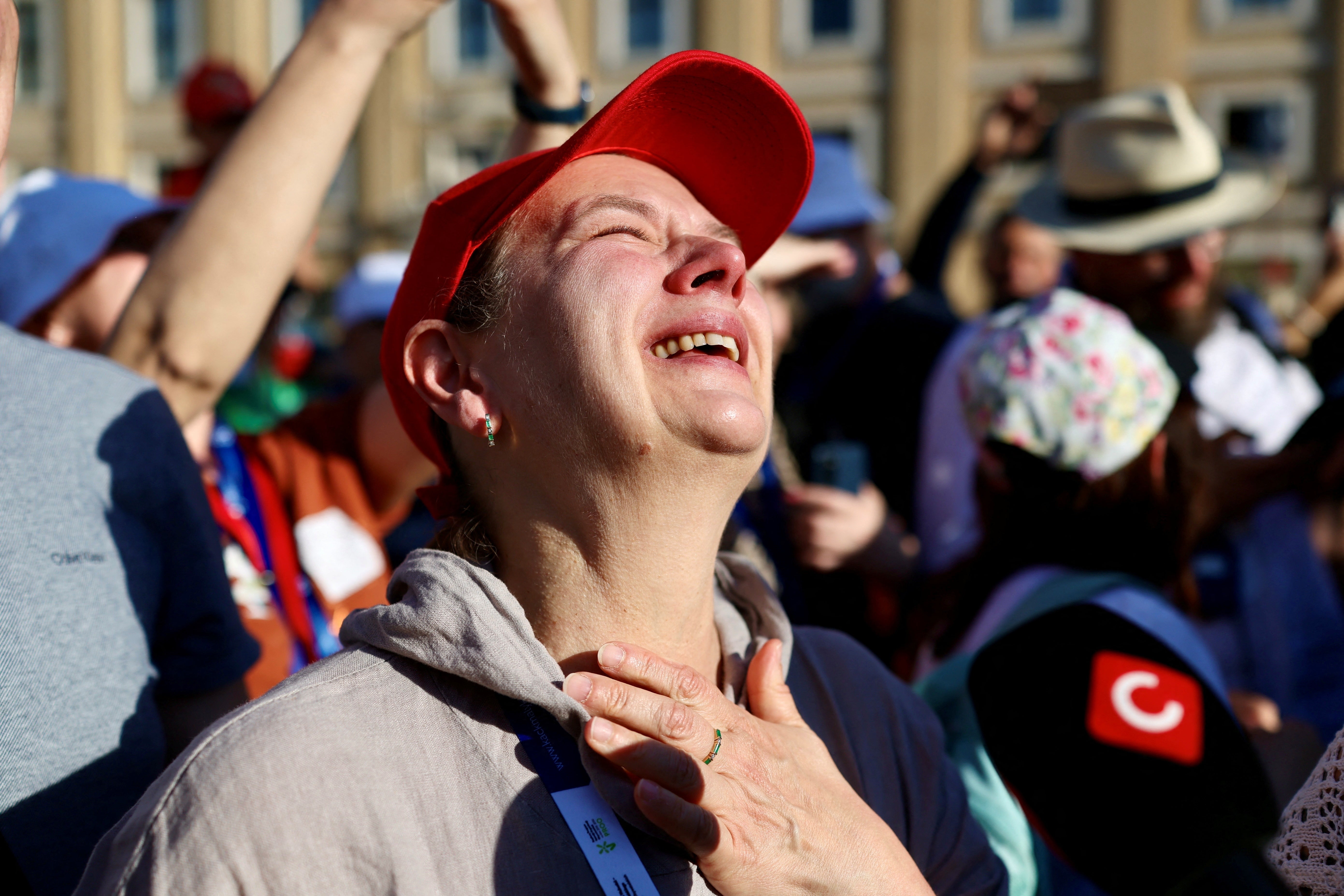 People react as white smoke rises from the chimney on the Sistine Chapel