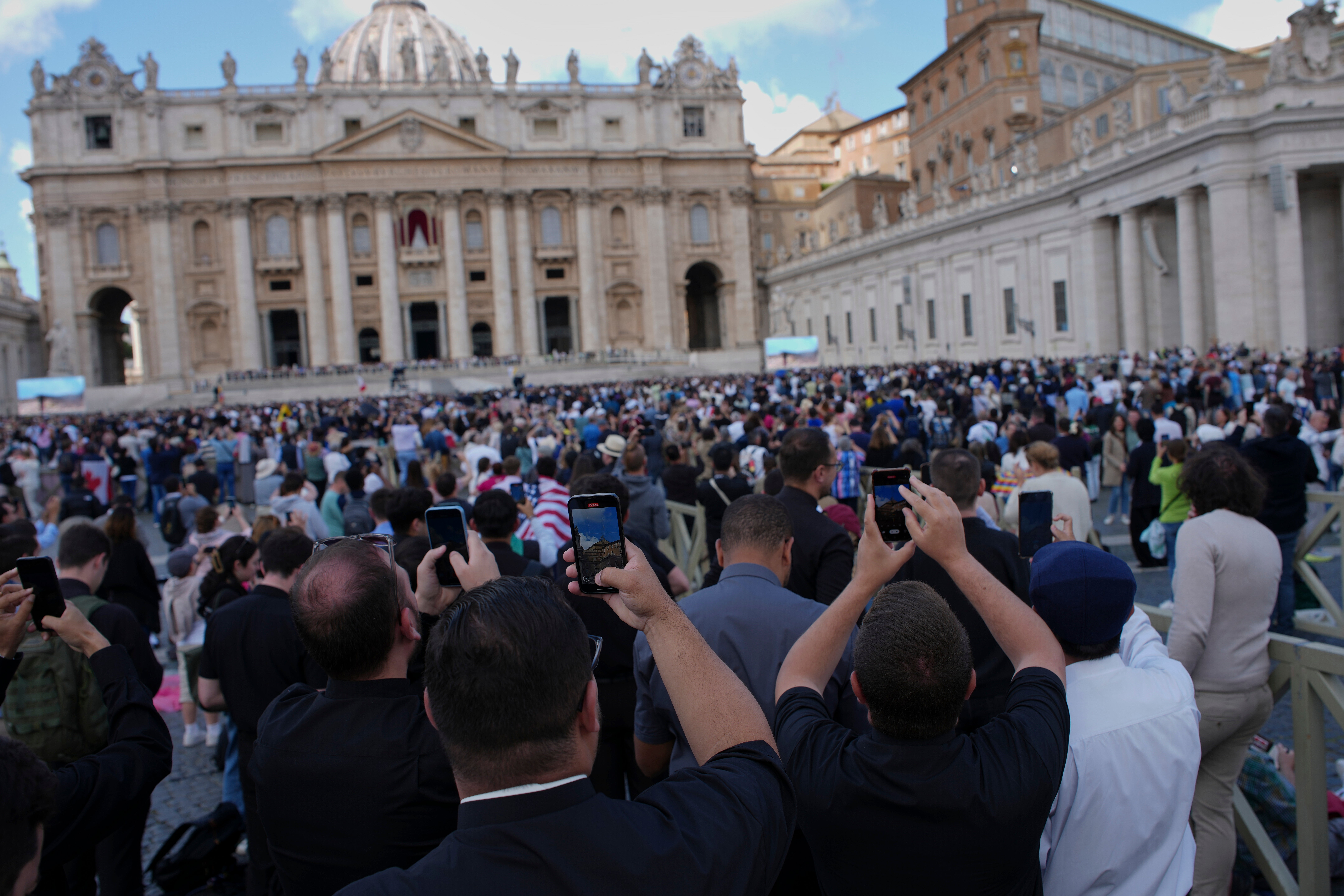 Faithful take photos as black smoke billows from the Sistine Chapel on the morning of May 8