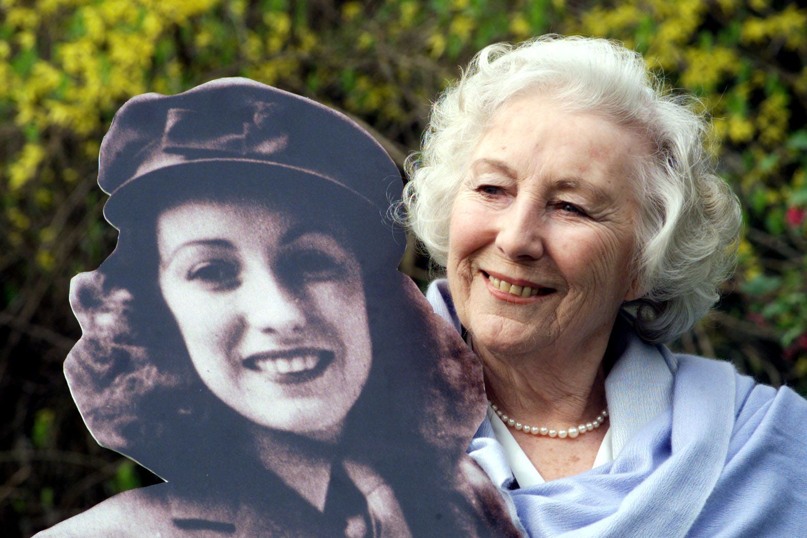 Dame Vera Lynn in 2020 with a picture of herself as a young woman (Sean Dempsey/PA)