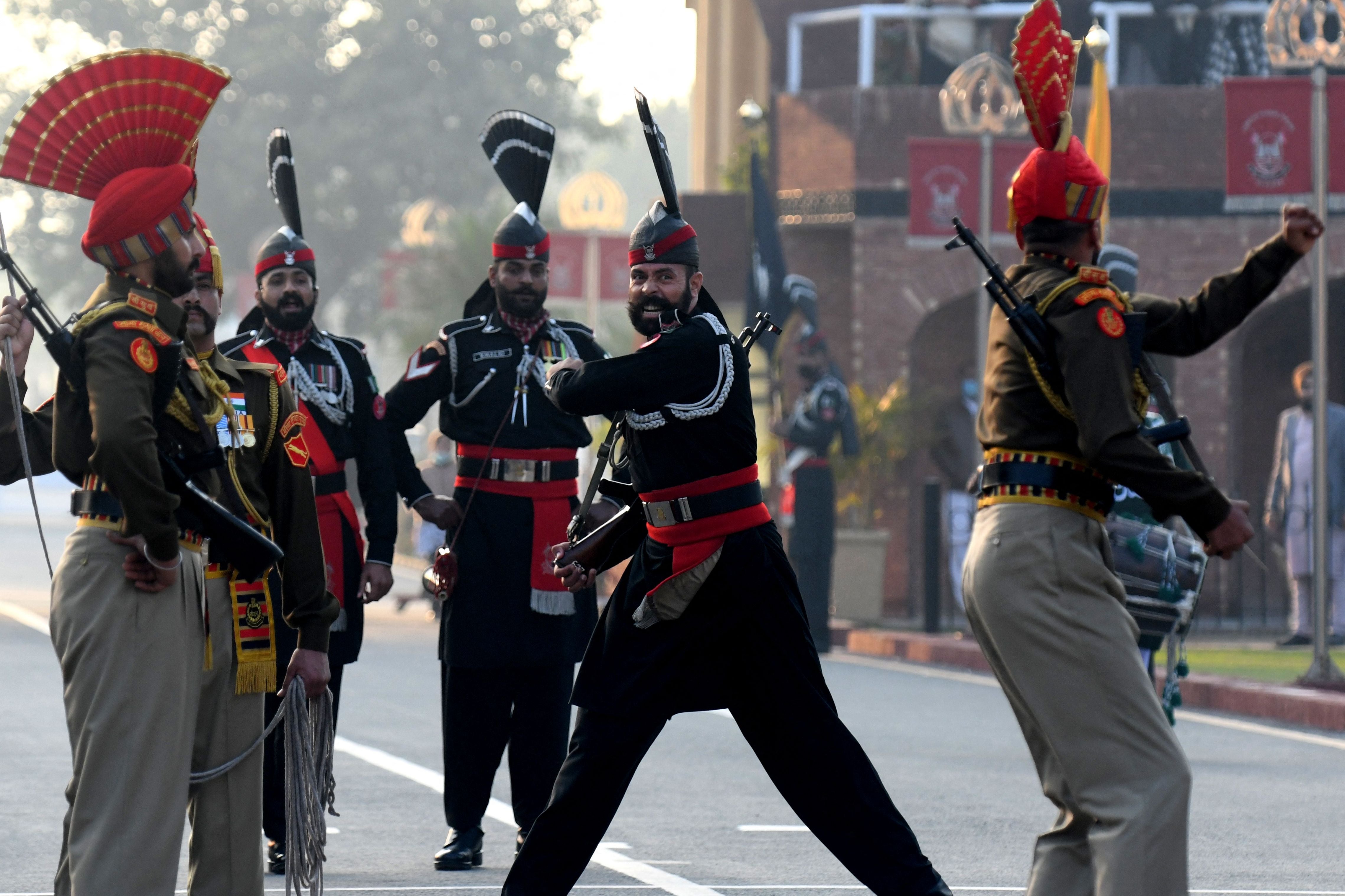 Indian Border Security Force personnel (dressed in brown) and Pakistani Rangers (dressed in black) take part in the Beating Retreat ceremony at the India-Pakistan Wagah border post