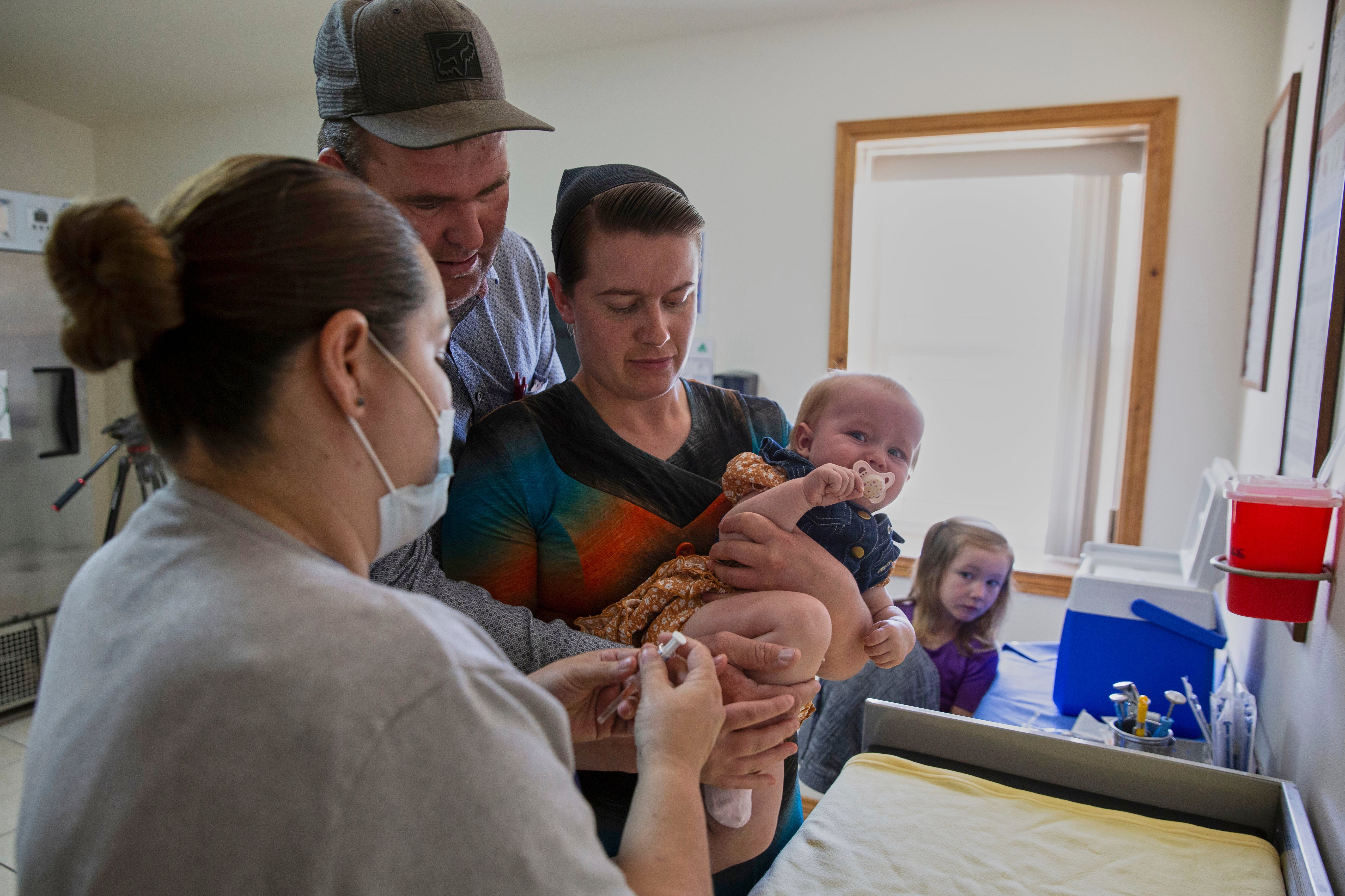 Mennonites Abraham Fehr and Katarina Wall hold their baby as he gets vaccinated weeks after the family fell sick with measles during an outbreak in Cuauhtemoc, Chihuahua state, Mexico, Thursday, May 1, 2025. (AP Photo/Megan Janetsky)