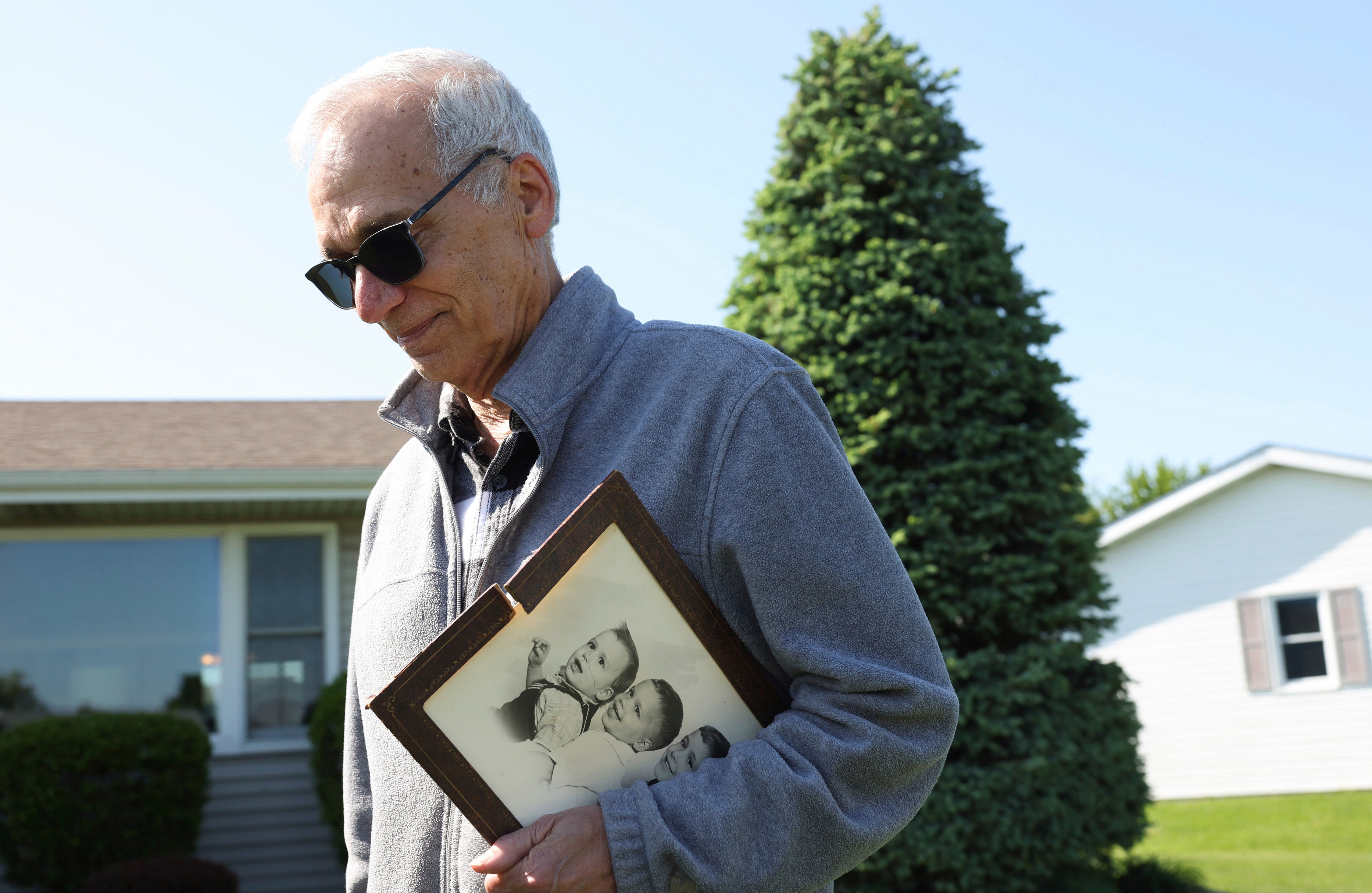 John Prevost, brother of Pope Leo XIV, holds a portrait of the three Prevost brothers from 1958