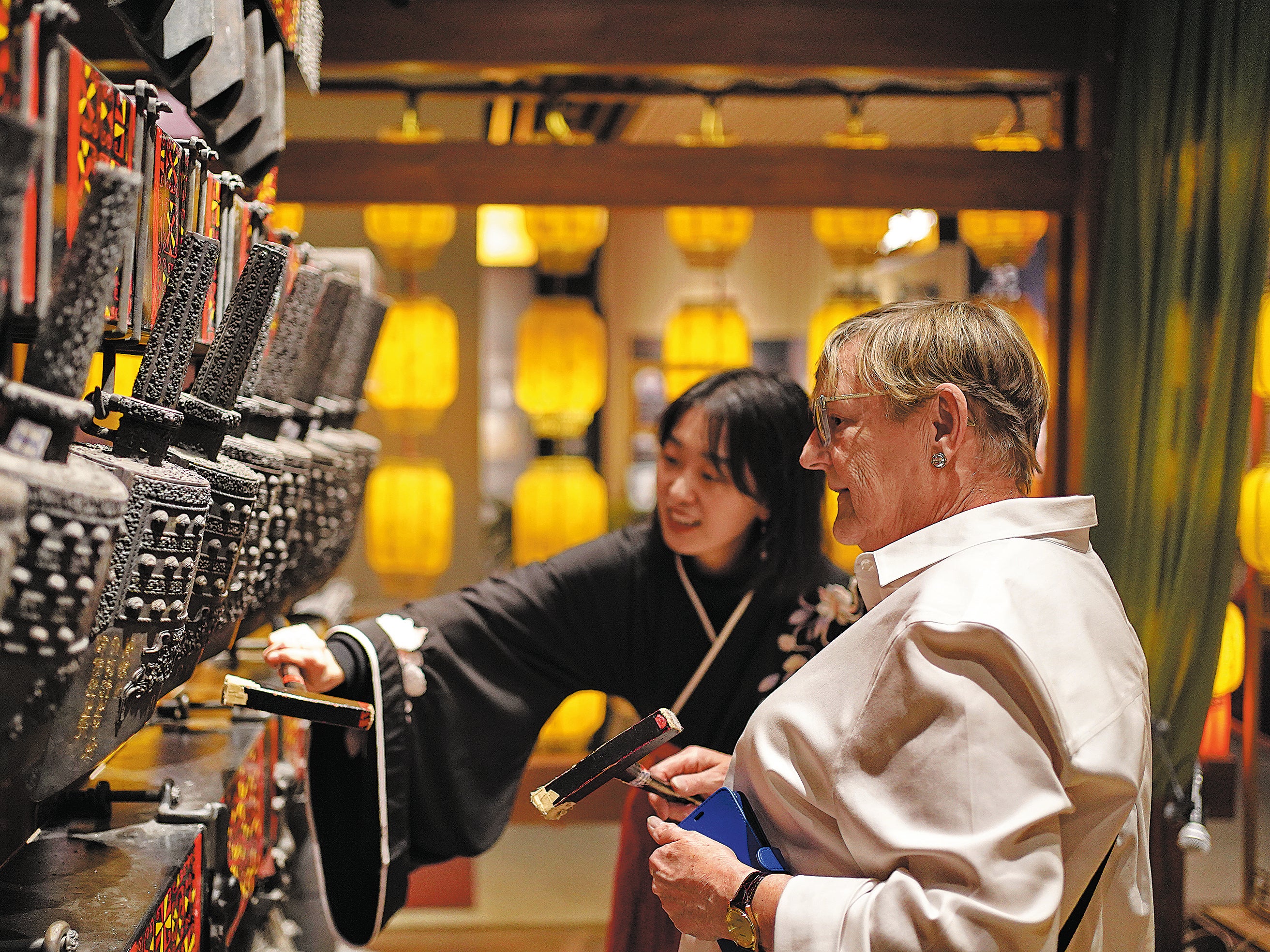 A foreign tourist learns to play bianzhong, or bronze chime bells, at the Oriental Music Cultural Museum in Dalian, Liaoning province, on 3 May