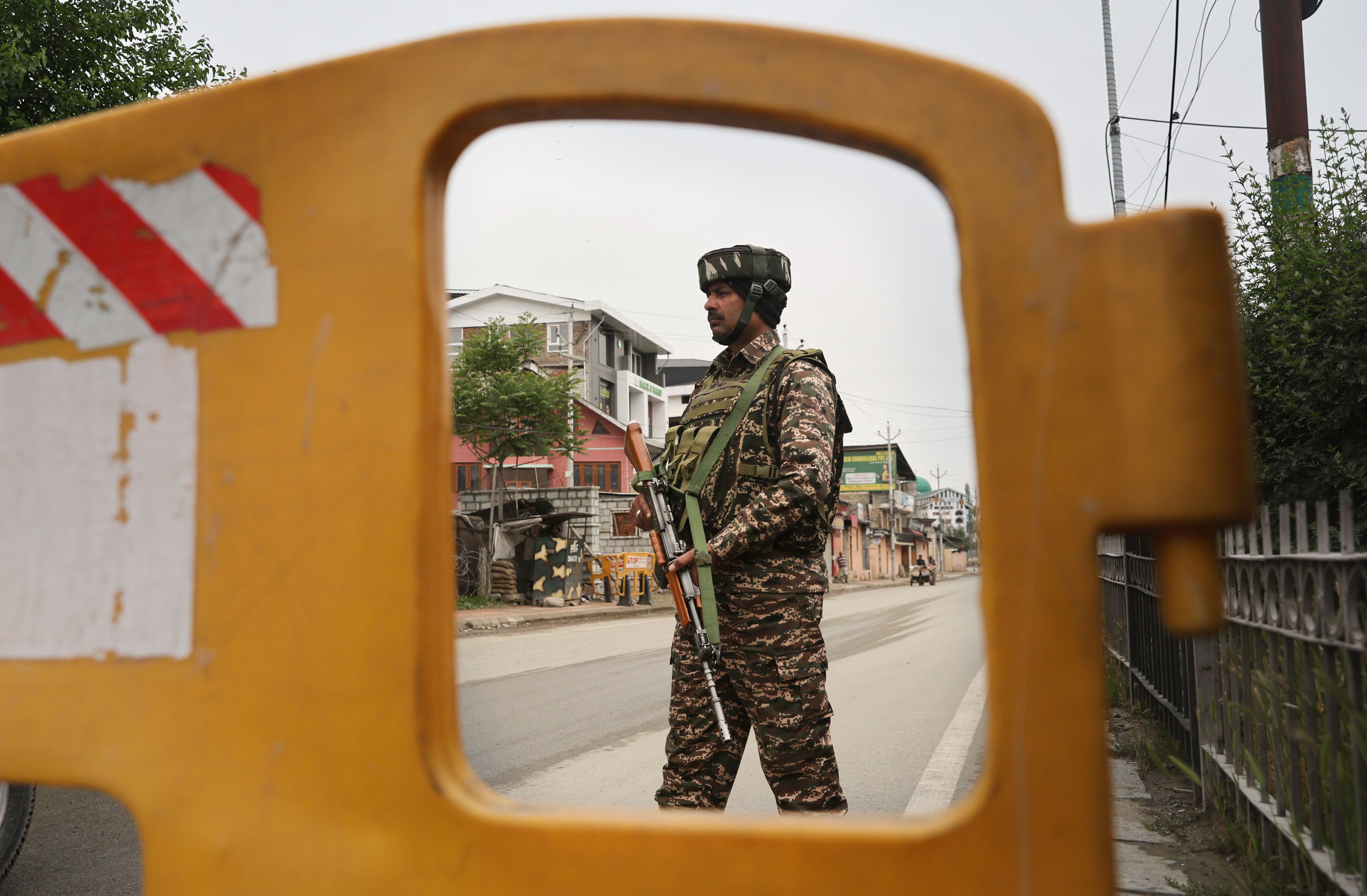 An Indian paramilitary soldier stands guard at a temporary check point on a road leading to the airport after loud explosions were heard in Srinagar, the summer of Indian Kashmir, 10 May 2025