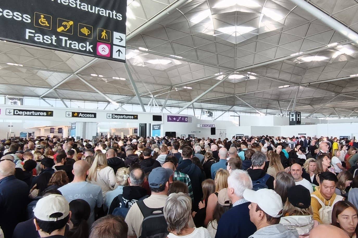 Passengers at Stansted Airport waiting for updates after an IT malfunction caused disruption and delays (Jonathan Goodacre/PA)