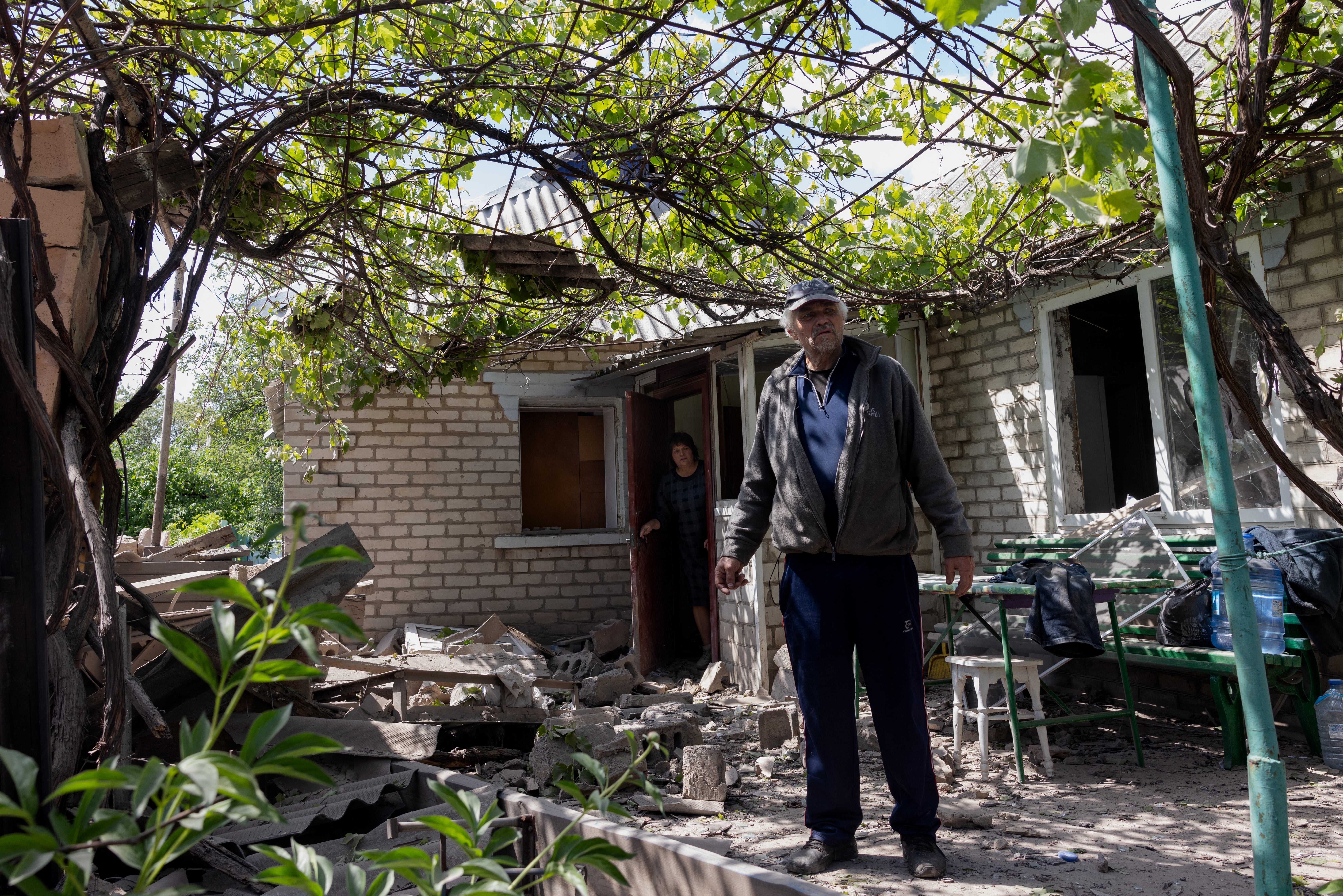 A resident stands next to a damaged home after Russian shelling in Kramatorsk, in the Donetsk region of Ukraine