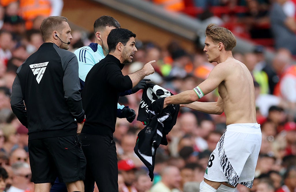 <p>Mikel Arteta passes instructions to his captain Martin Odegaard</p>