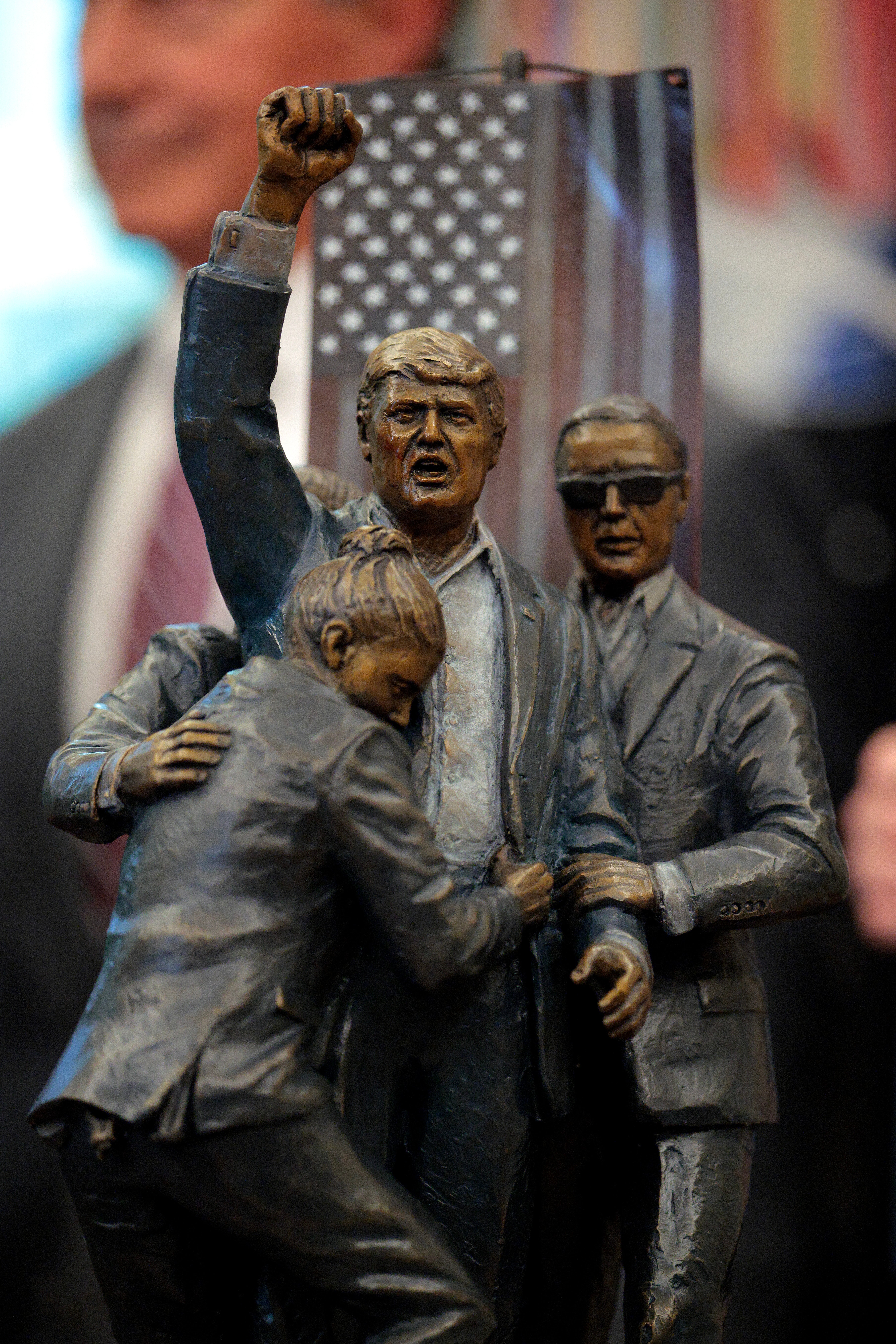 The statue, featuring the Secret Service agents who bundled Trump to the ground, was created by sculptor Stan Watts and ‘symbolizes the divine intervention as well as the man and his message of unity and resilience for which America stands,’ according to the Trump Statue Project’s website.